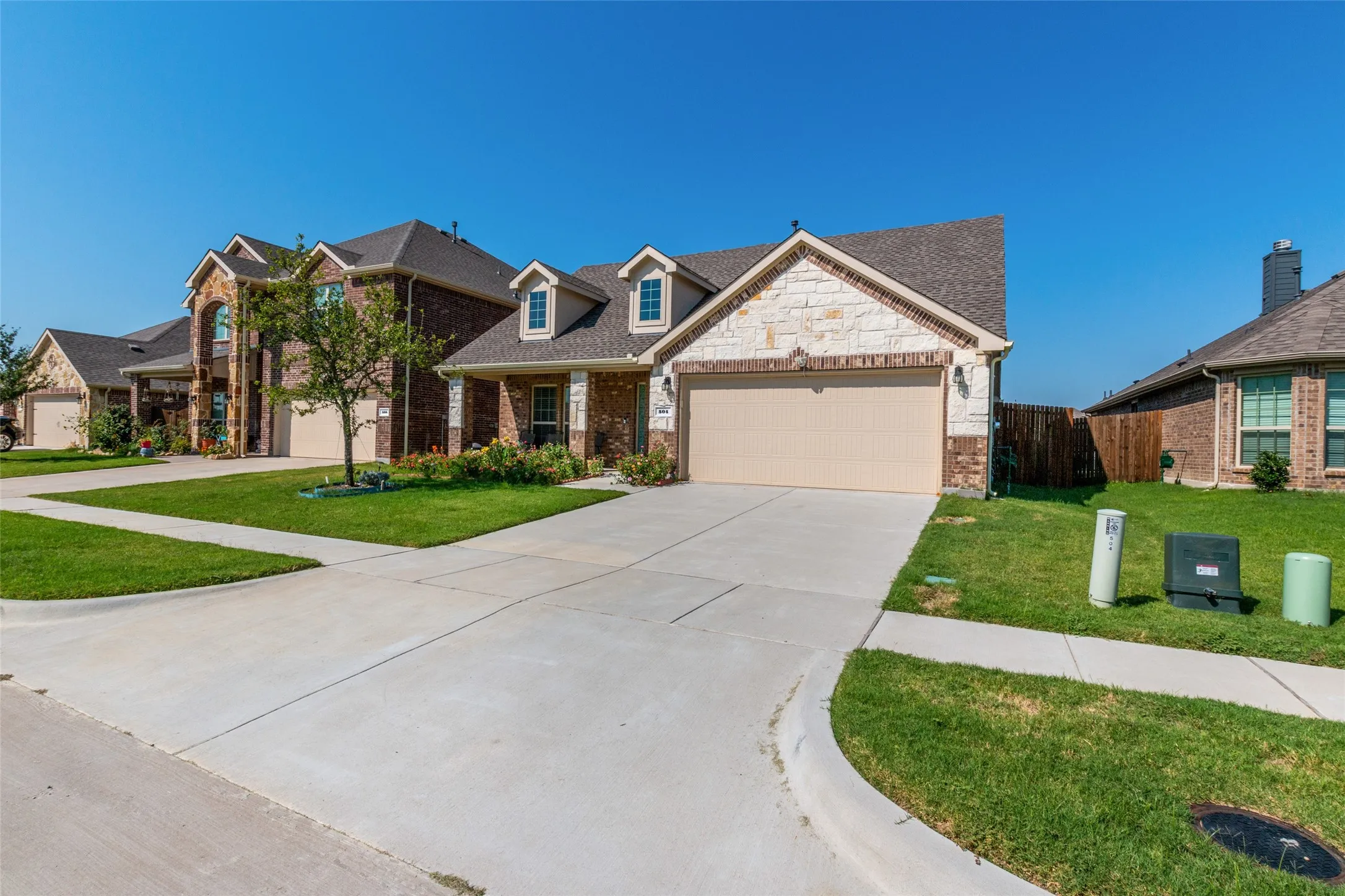 View of front of home with brick siding, concrete driveway, and a garage