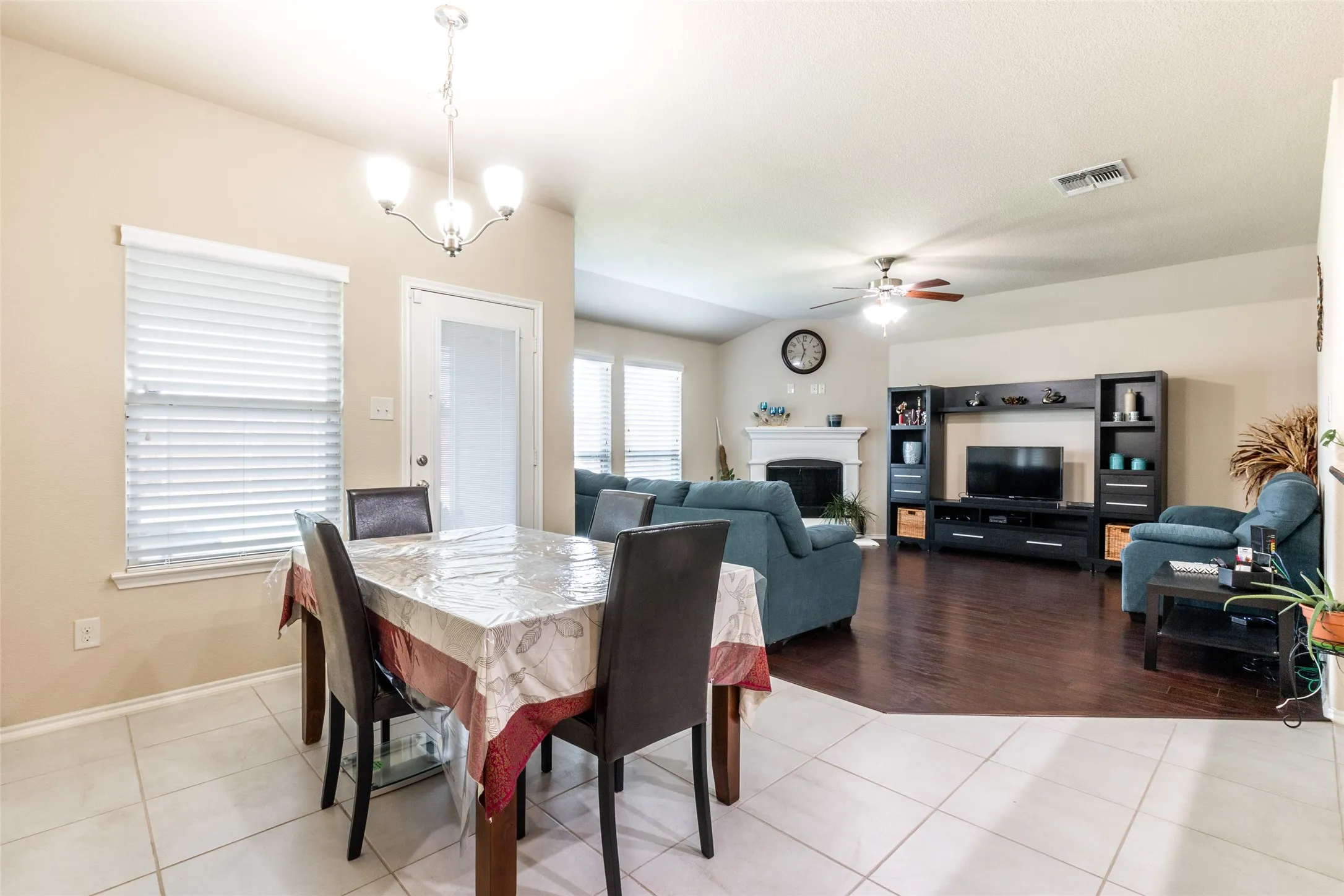 Dining room featuring a ceiling fan, light tile patterned floors, and a fireplace