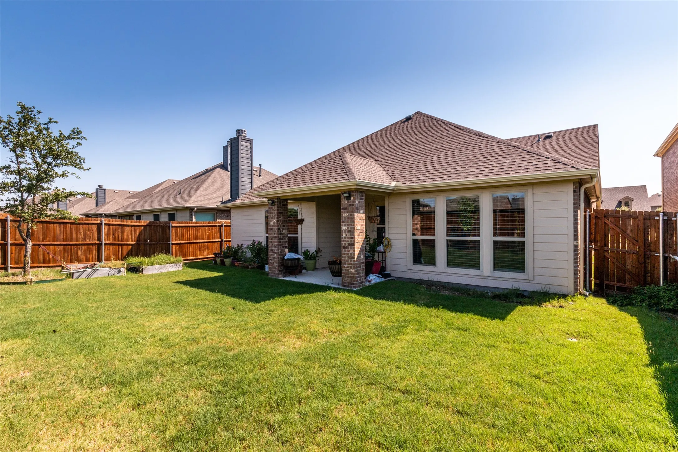 Back of house featuring a fenced backyard and a shingled roof