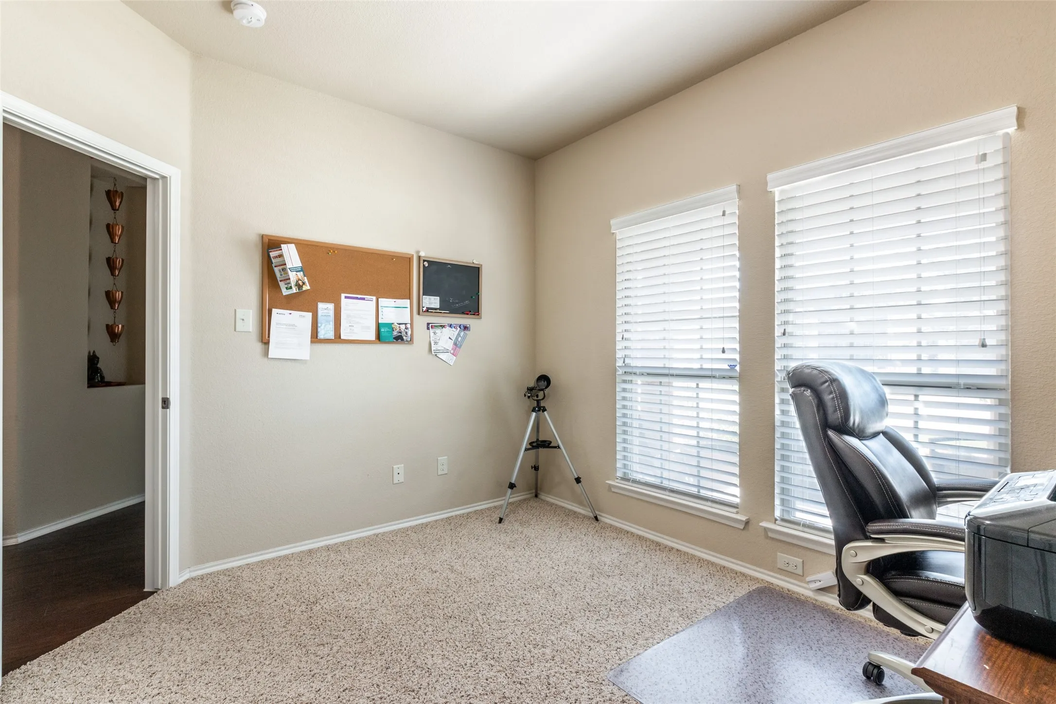 Carpeted home office featuring baseboards
