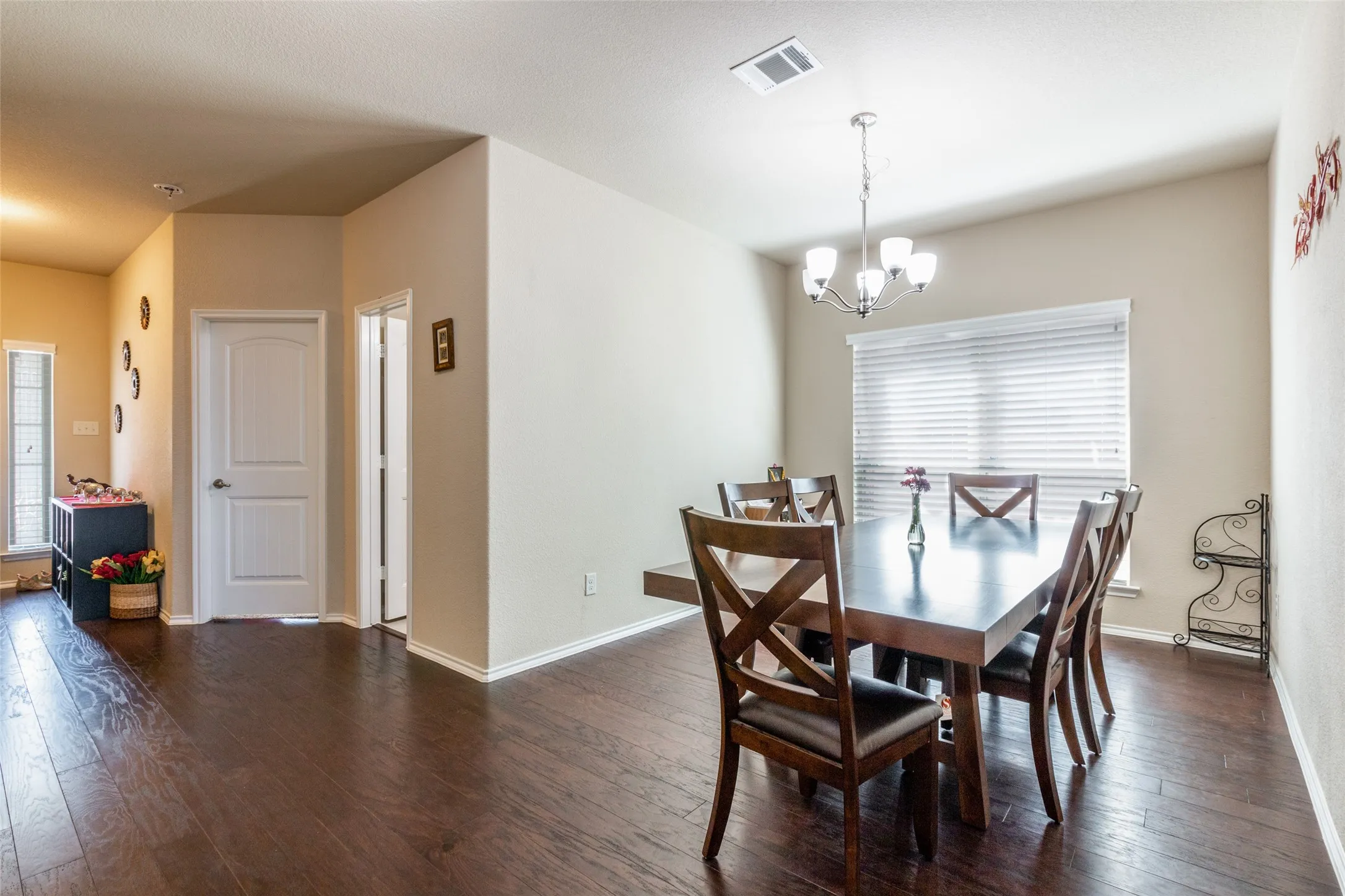 Dining room featuring dark wood-style floors and a chandelier