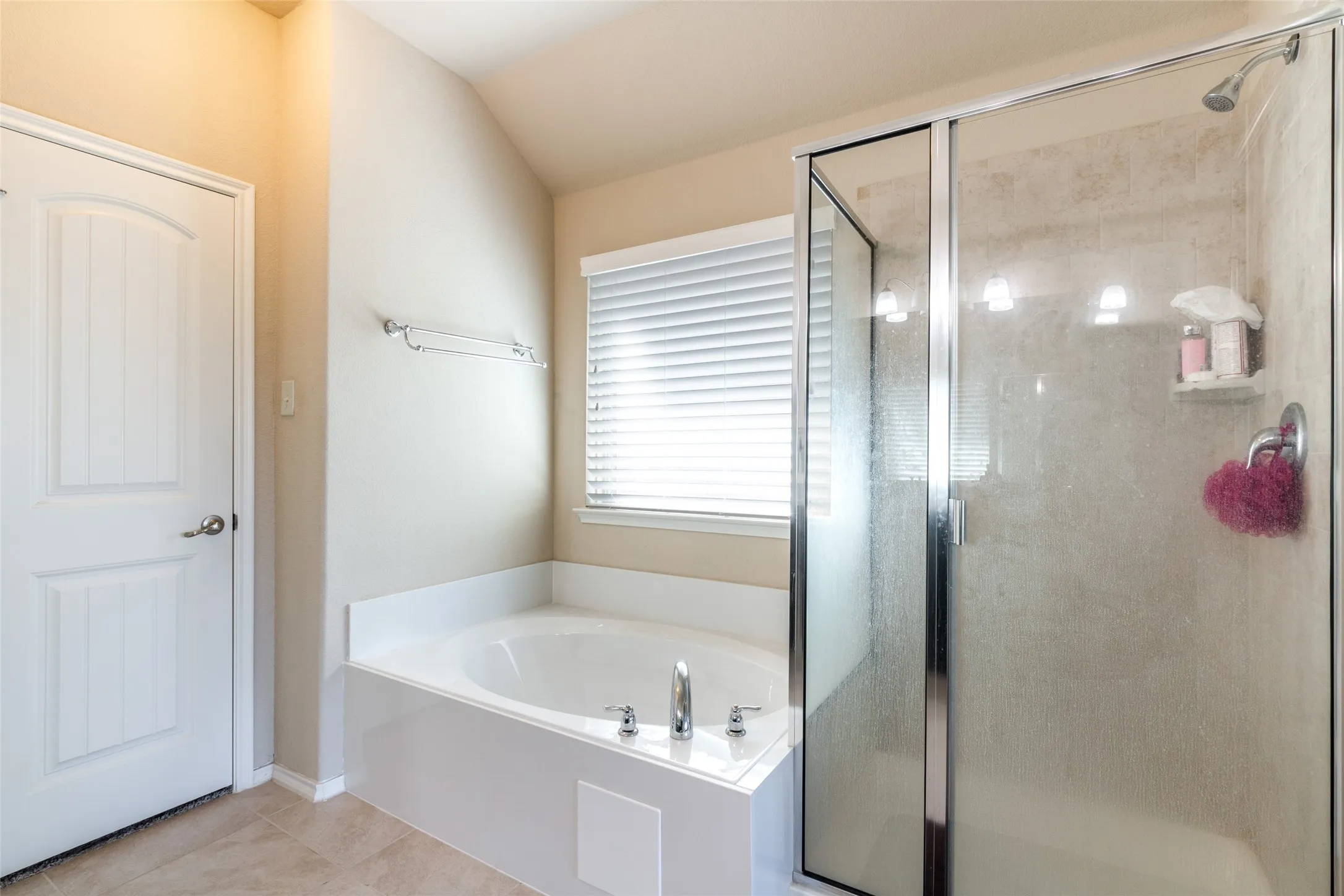 Full bath featuring a stall shower, a bath, tile patterned flooring, and vaulted ceiling