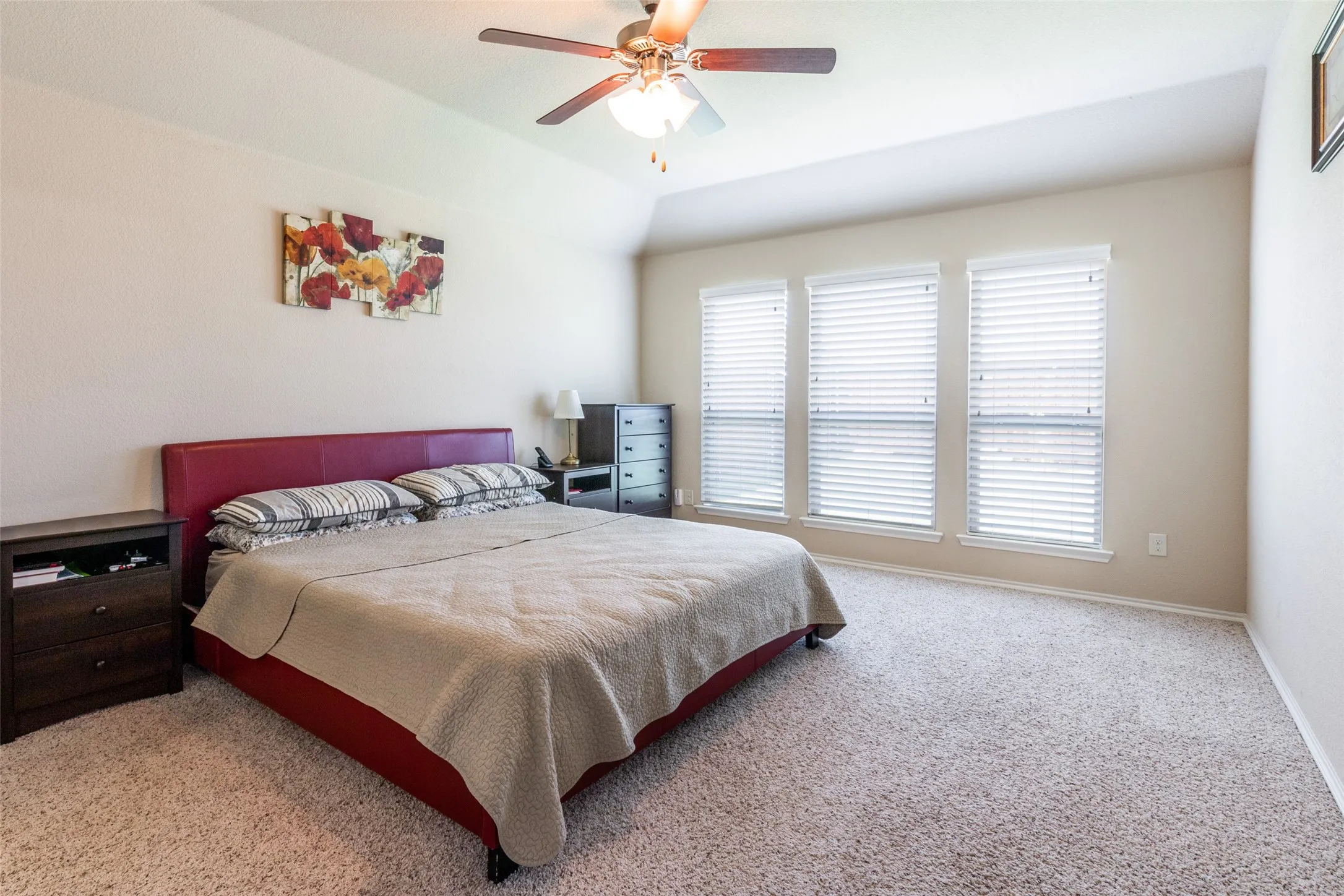 Bedroom with multiple windows, carpet flooring, and a ceiling fan