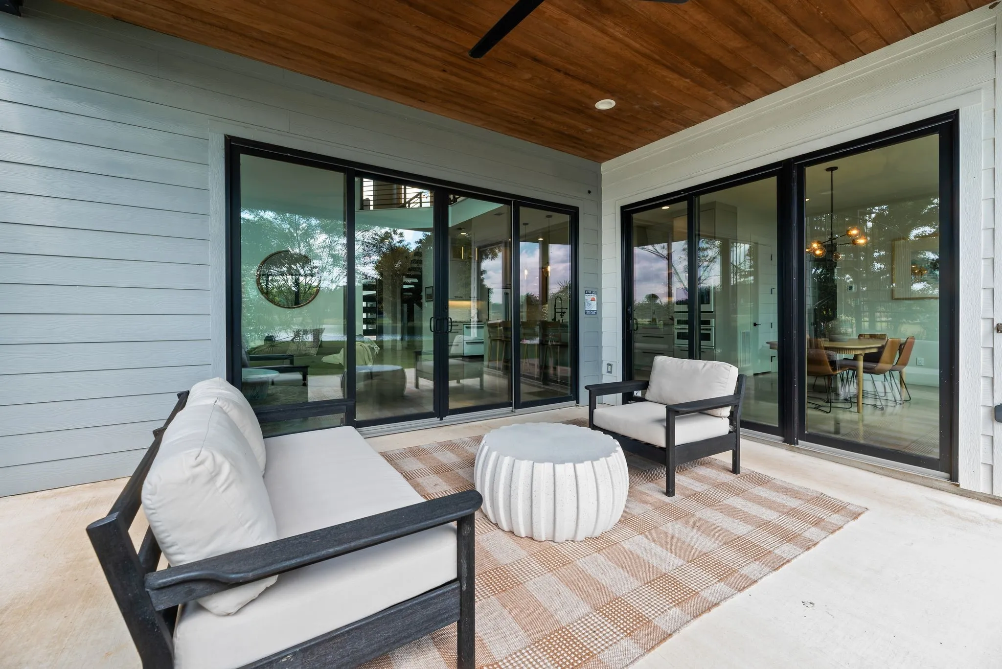 Covered back porch extends the living and dining areas outdoors with a comfortable space for relaxing and entertaining near the water.
