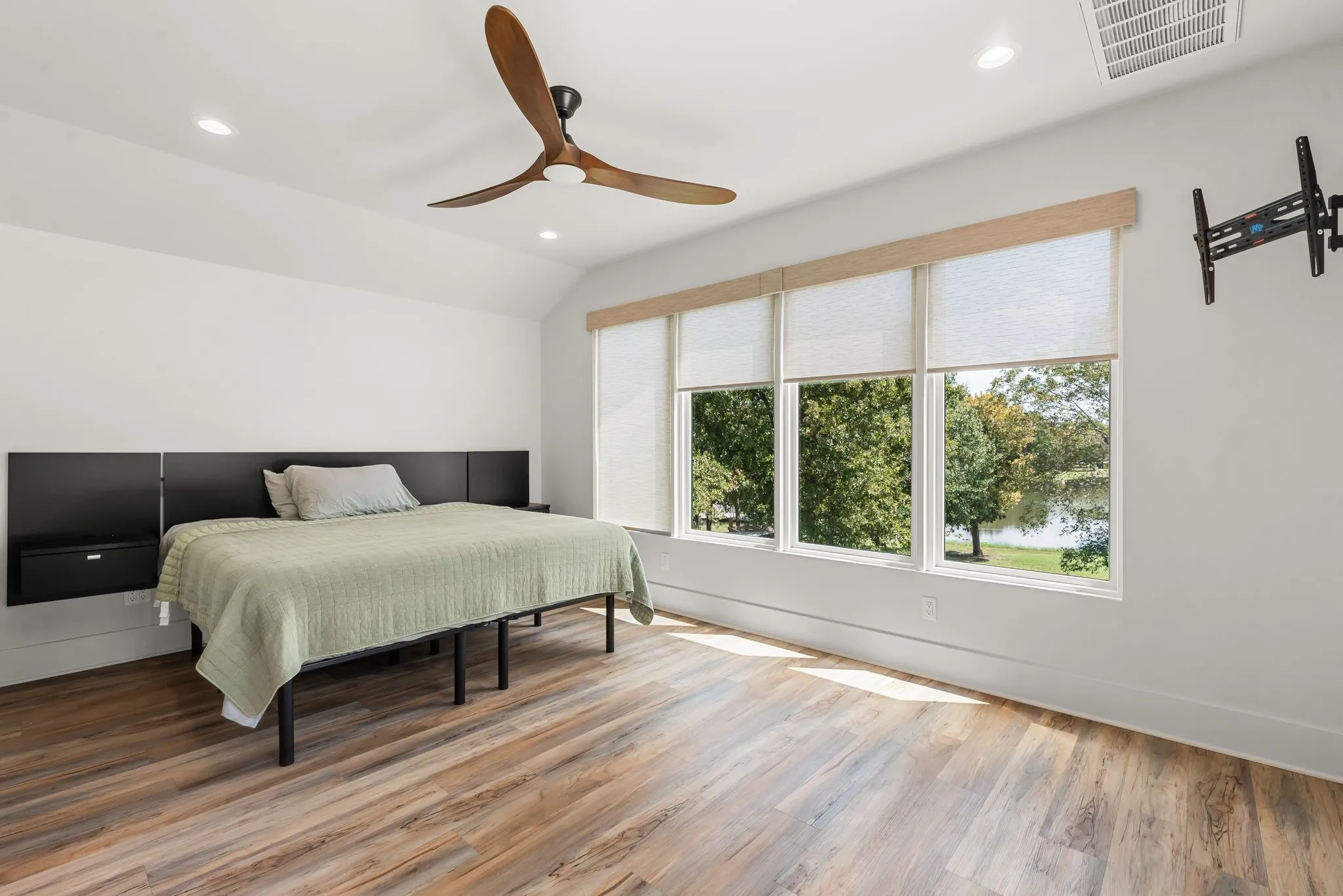 Spacious secondary bedroom features abundant natural light and direct access to a private outdoor balcony overlooking the property.