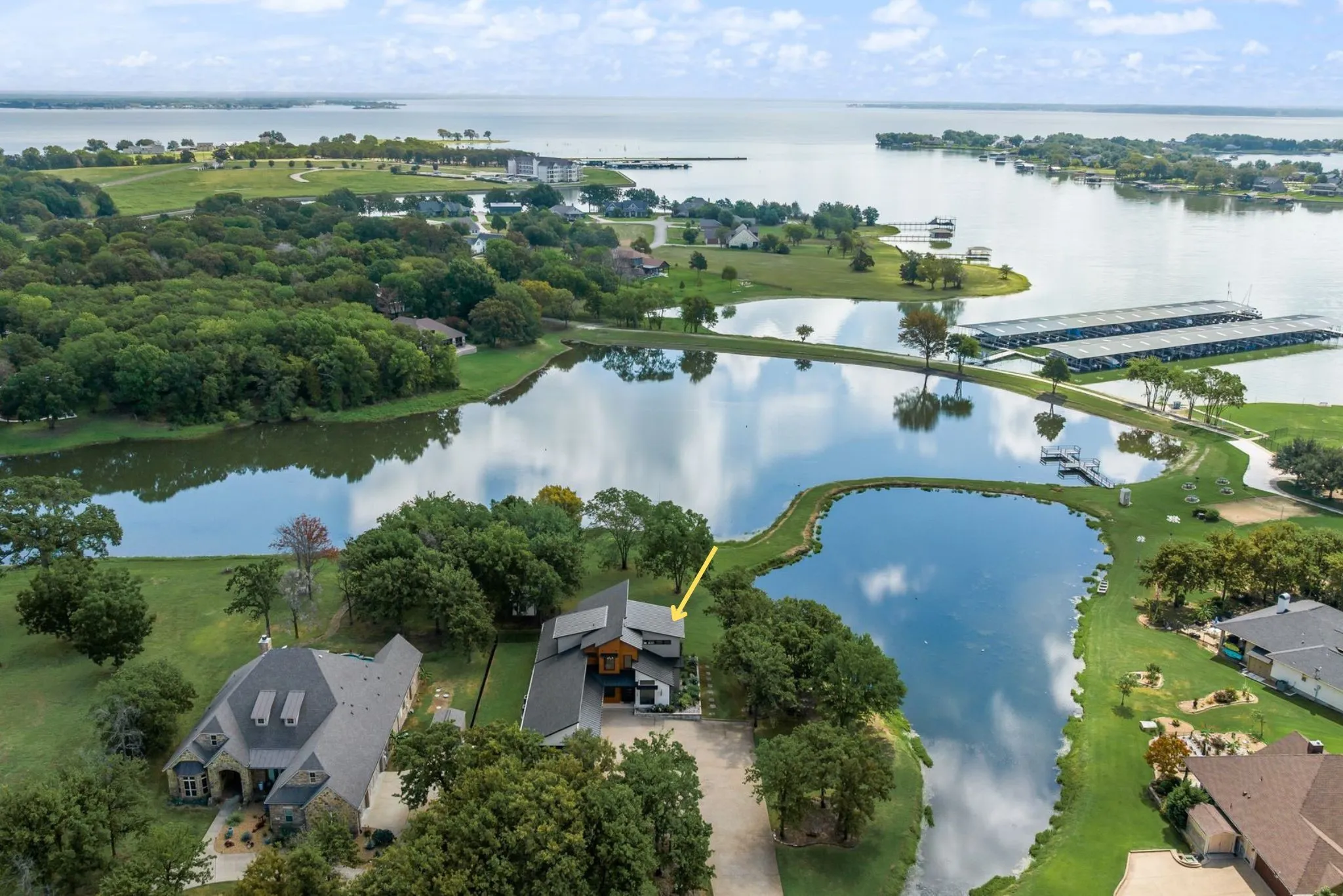 Aerial view of 708 Clear Water Court showcasing the contemporary lake home, waterfront setting, private pond frontage, and Richland Chambers Lake surroundings in Corsicana, Texas.