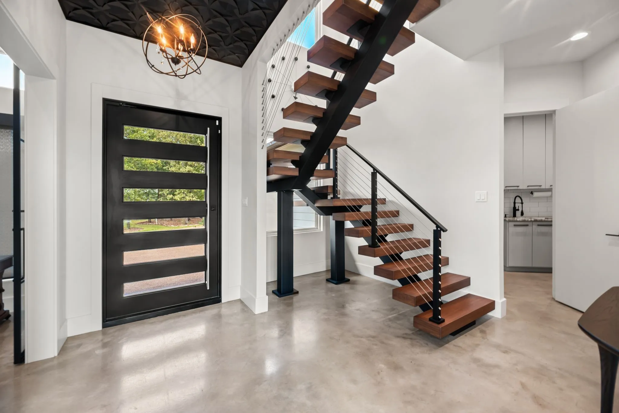 Striking entryway at 708 Clear Water Court features a contemporary staircase and modern architectural details leading to the second floor.