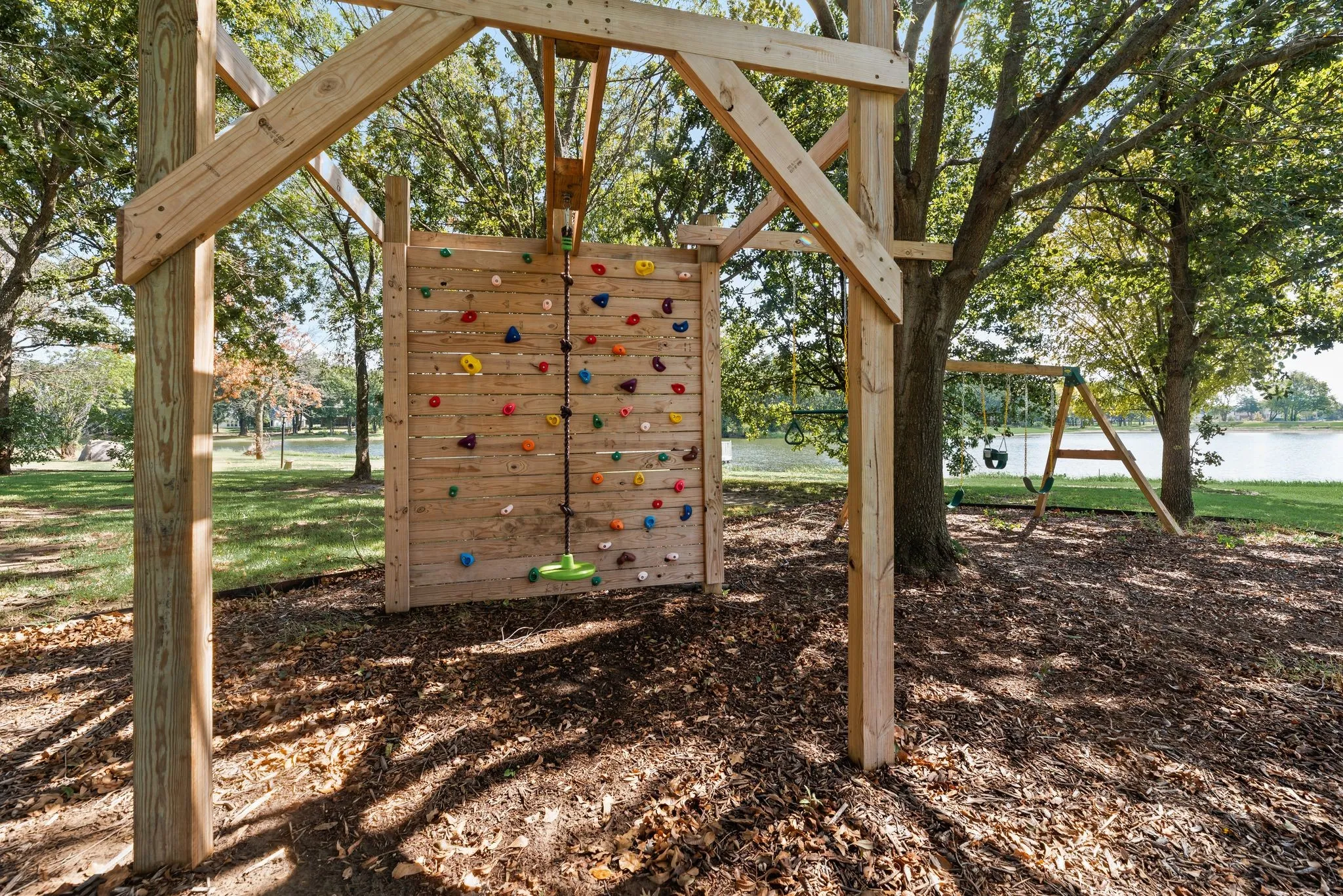 Outdoor climbing wall tucked beneath mature trees adds a fun recreational feature to the spacious grounds at 708 Clear Water Court.