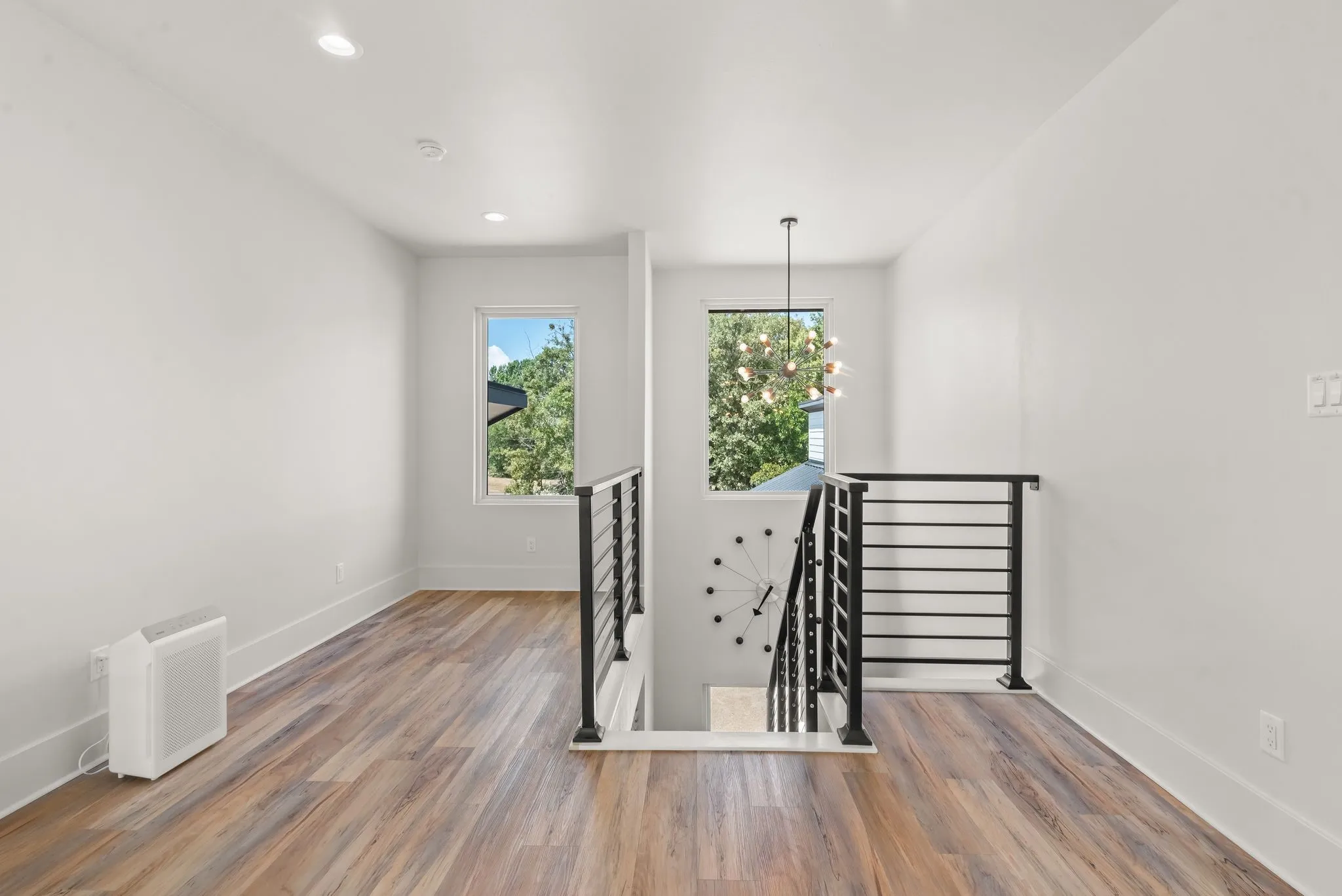 Open second-floor landing provides access to the upstairs bedrooms while overlooking the home's dramatic main living area.