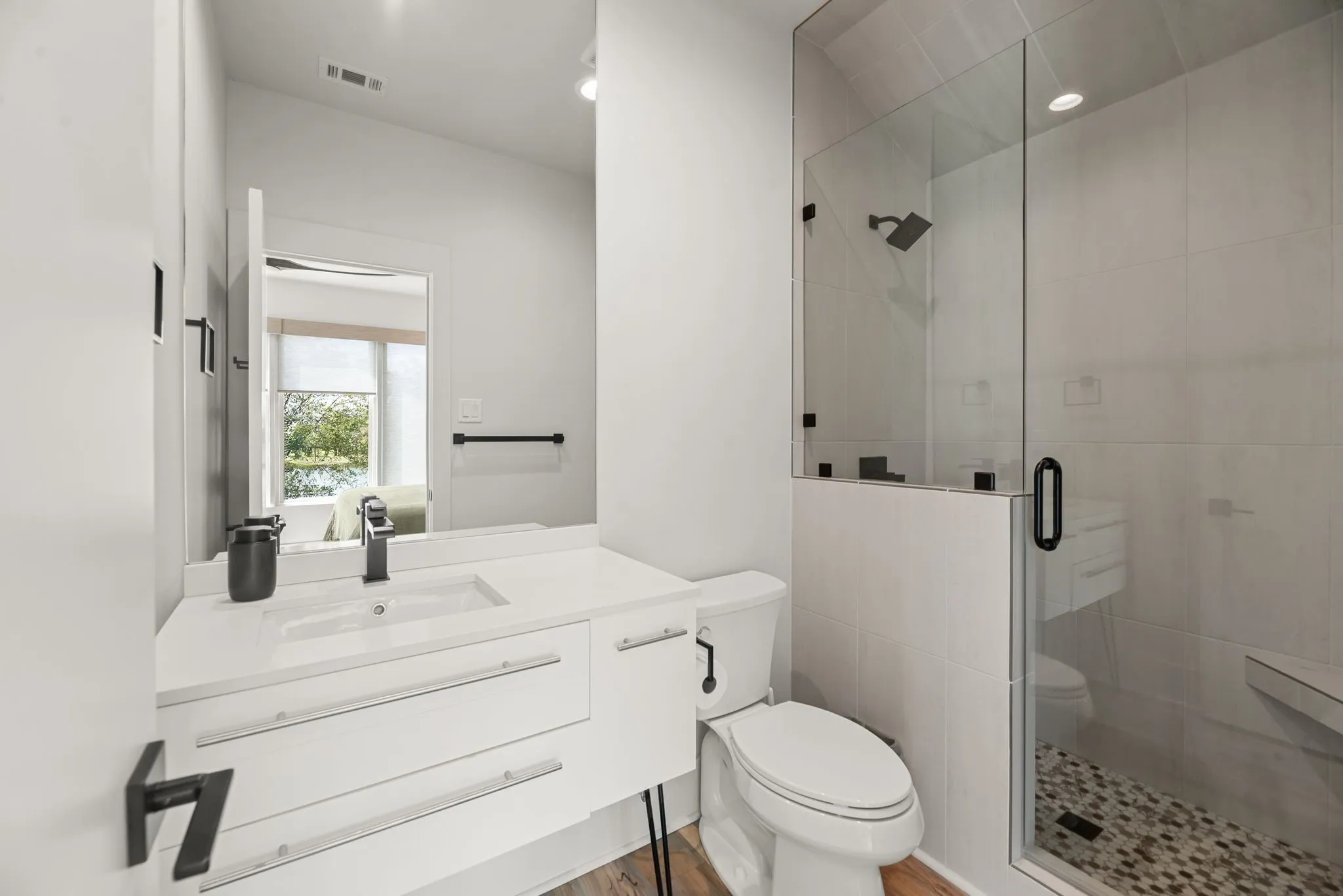 Well-appointed upstairs ensuite bathroom offers modern fixtures, generous vanity space, and convenient privacy for guests.