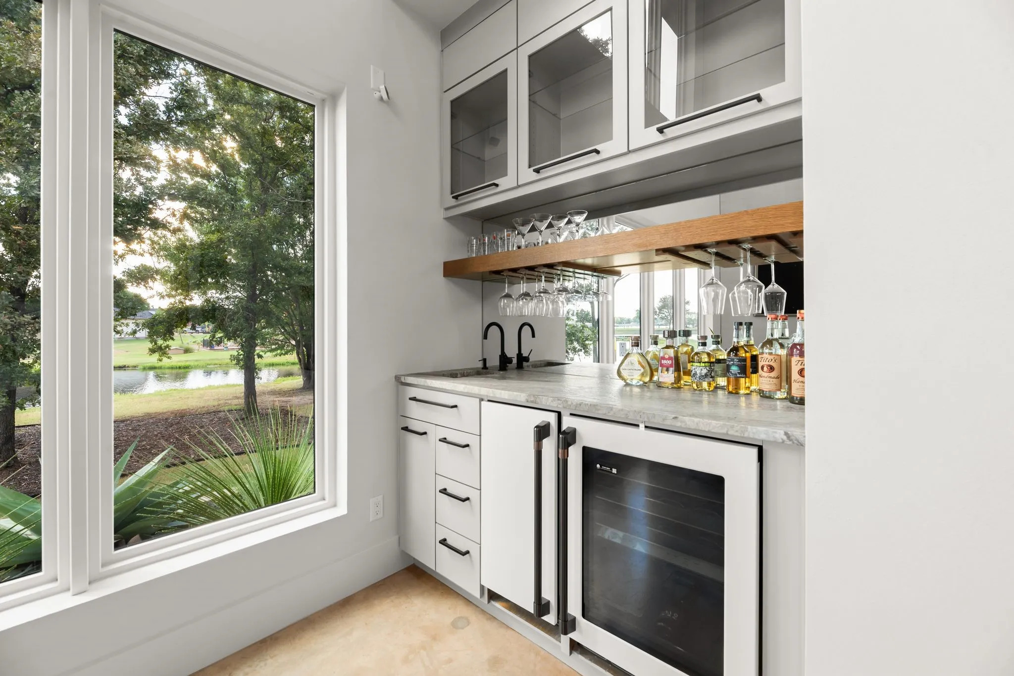 Stylish built-in wet bar in the living room features cabinetry, counter space, a wine cooler, and convenient storage for entertaining.