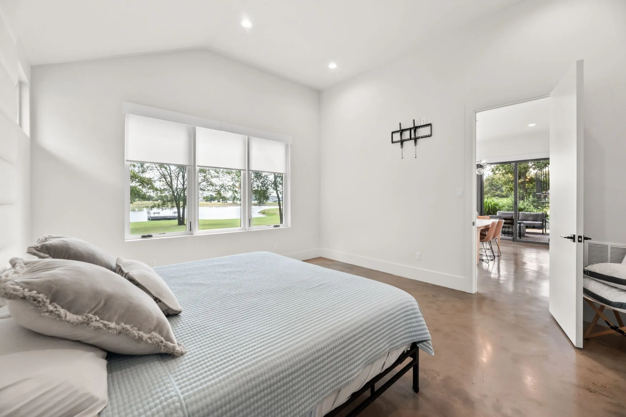 Main-level primary suite features large windows, peaceful water views, and direct access to a spacious ensuite bath.
