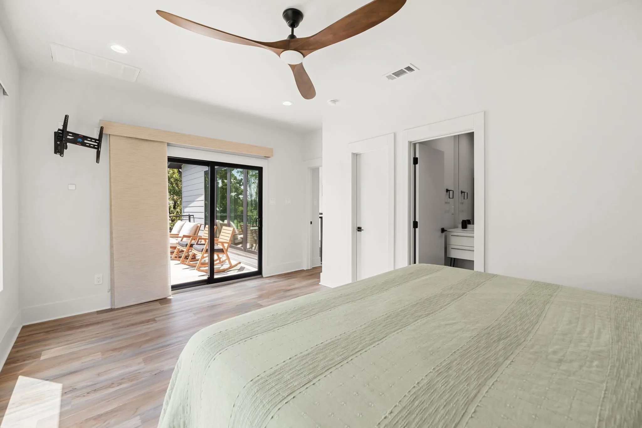 Bright secondary bedroom provides a comfortable private retreat with attractive flooring, ceiling fan, and generous natural light.