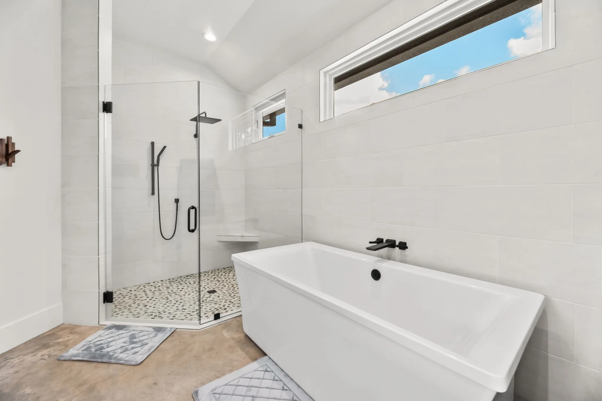 Spa-inspired primary bath includes a freestanding soaking tub and oversized walk-in shower with body sprays for a relaxing private retreat.