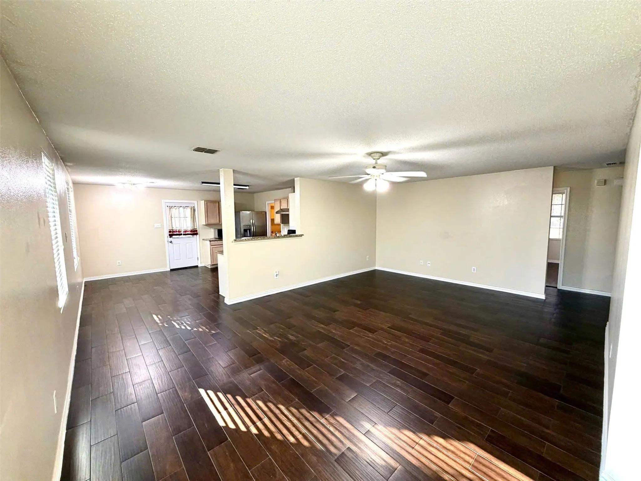 Spacious room with dark wood-finish flooring