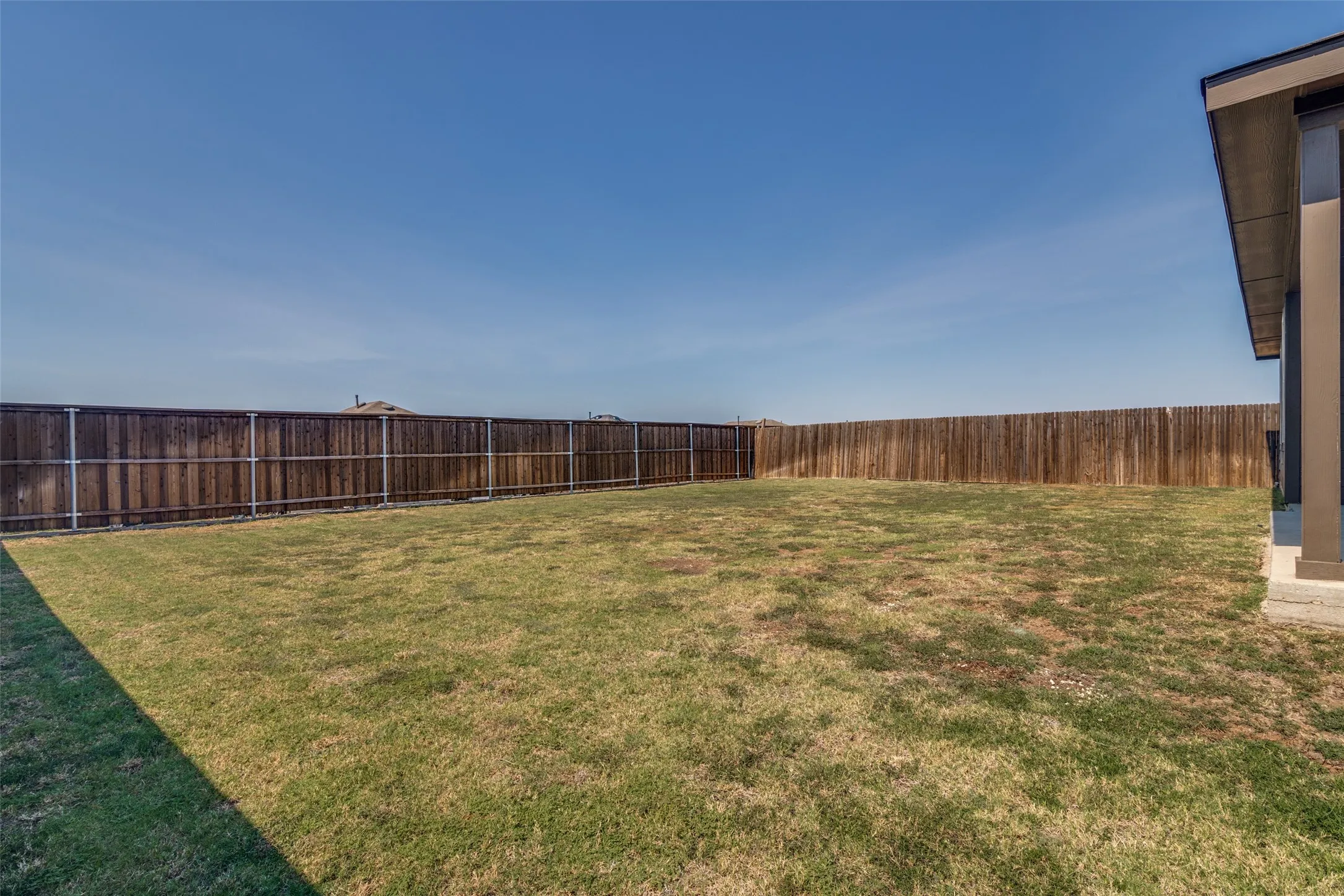 Expansive lawn area with a perimeter privacy fence