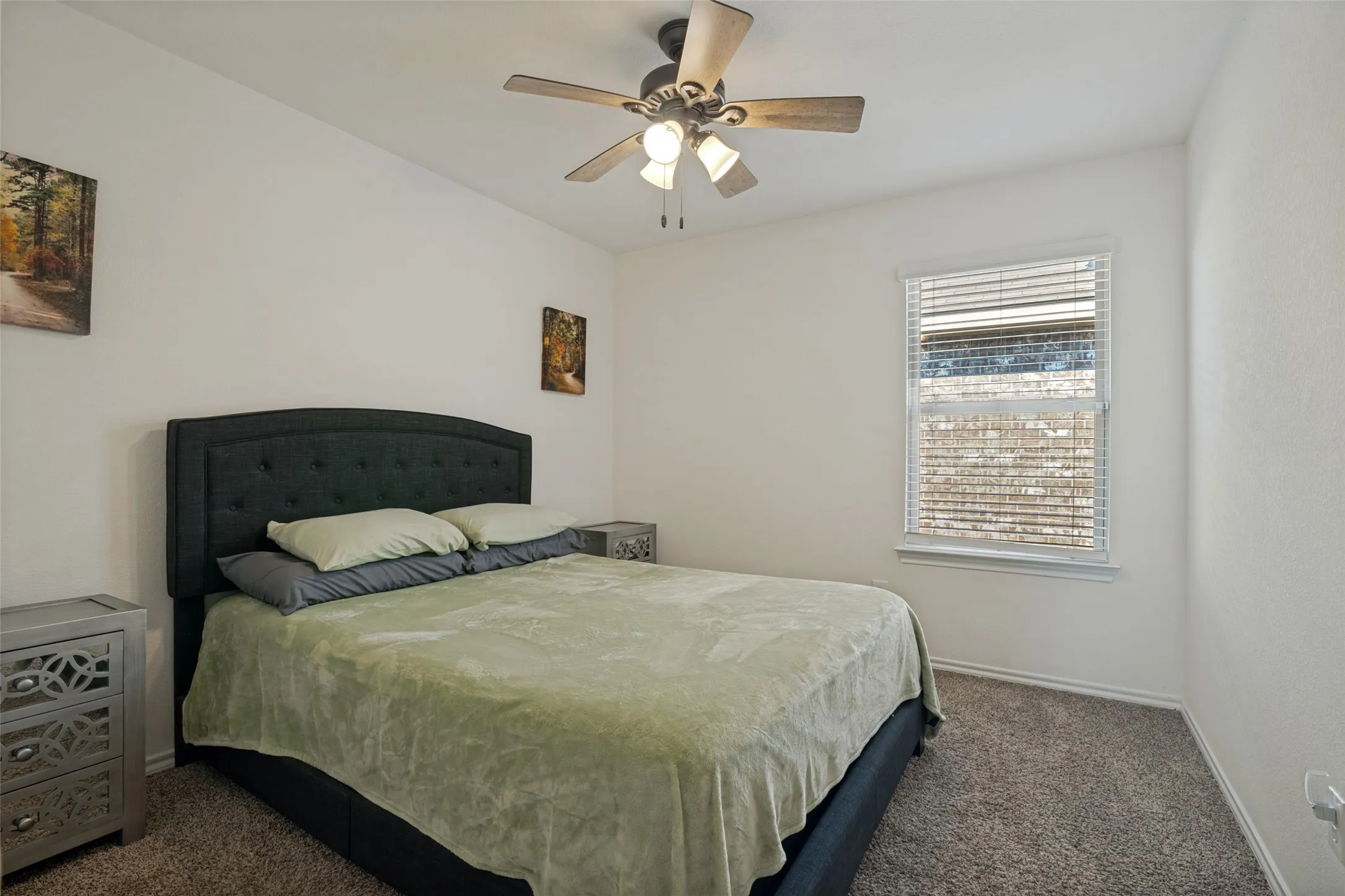 White walls featuring a single window with blinds and a ceiling fan with light fixture