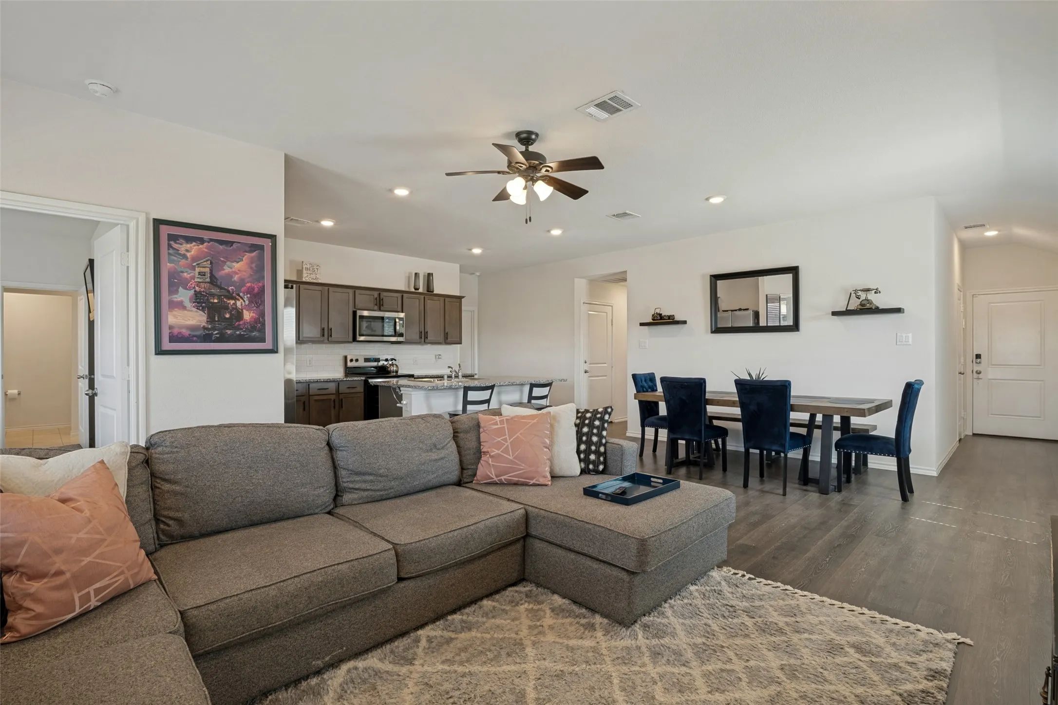 Open-concept living space featuring wood-finish flooring, recessed lighting, and a ceiling fan