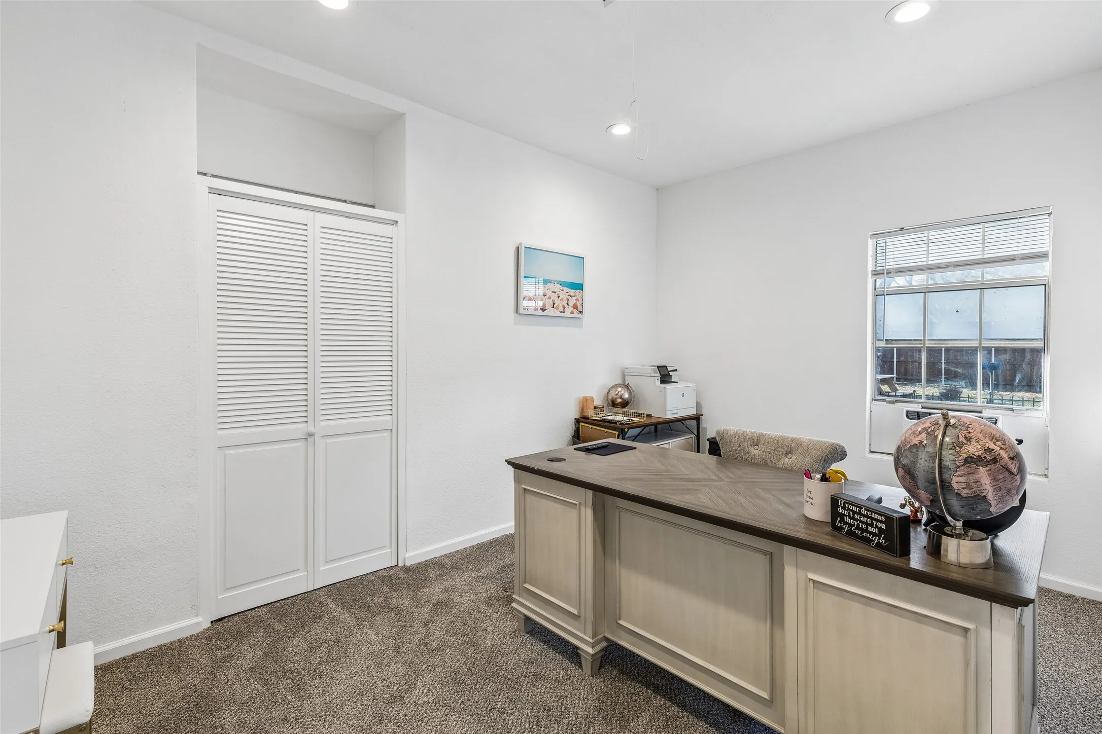 Recessed lighting, window with blinds, louvered bi-fold doors, white walls, and carpet flooring