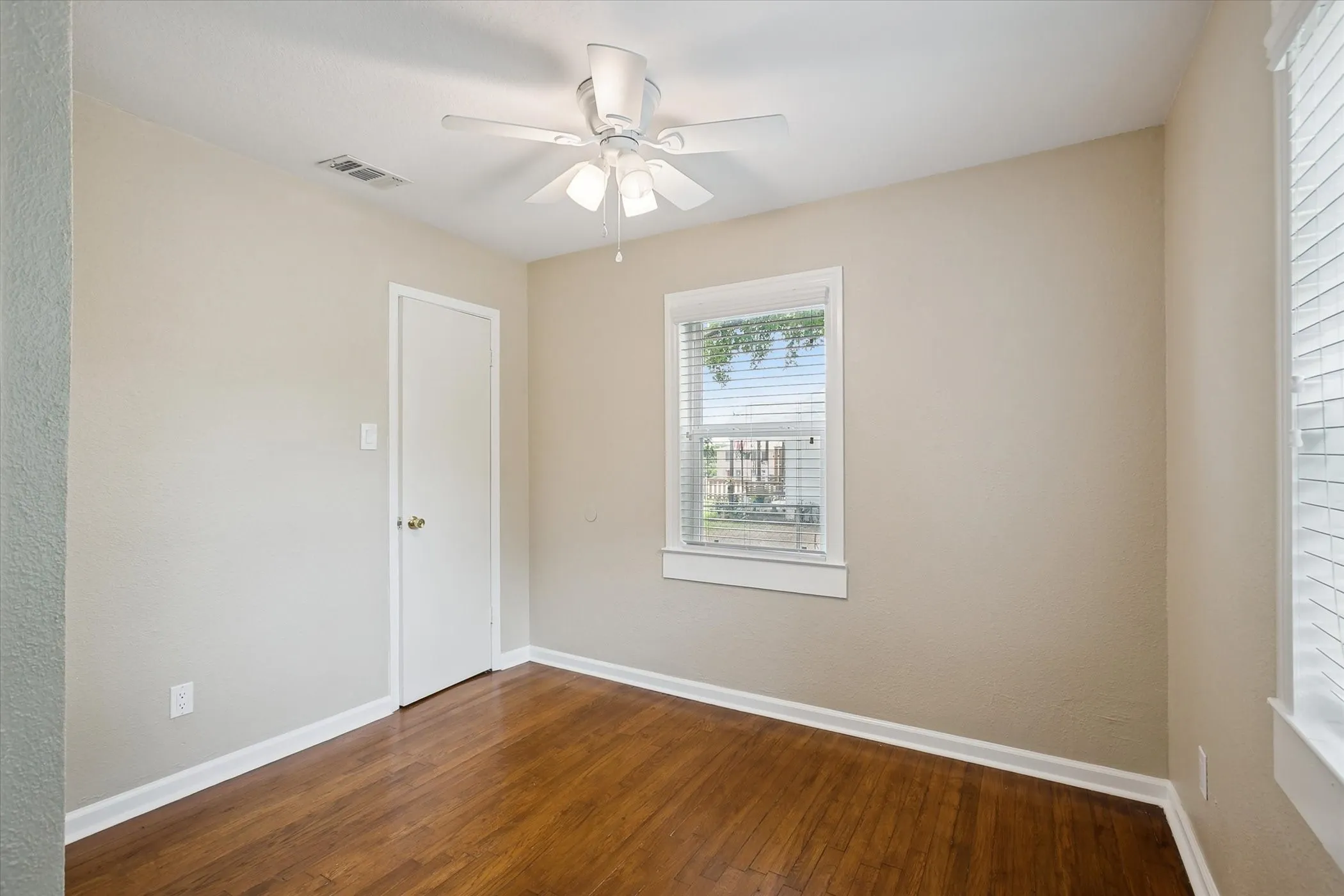 Second bedroom with wood floors, lots of natural light and ceiling fan