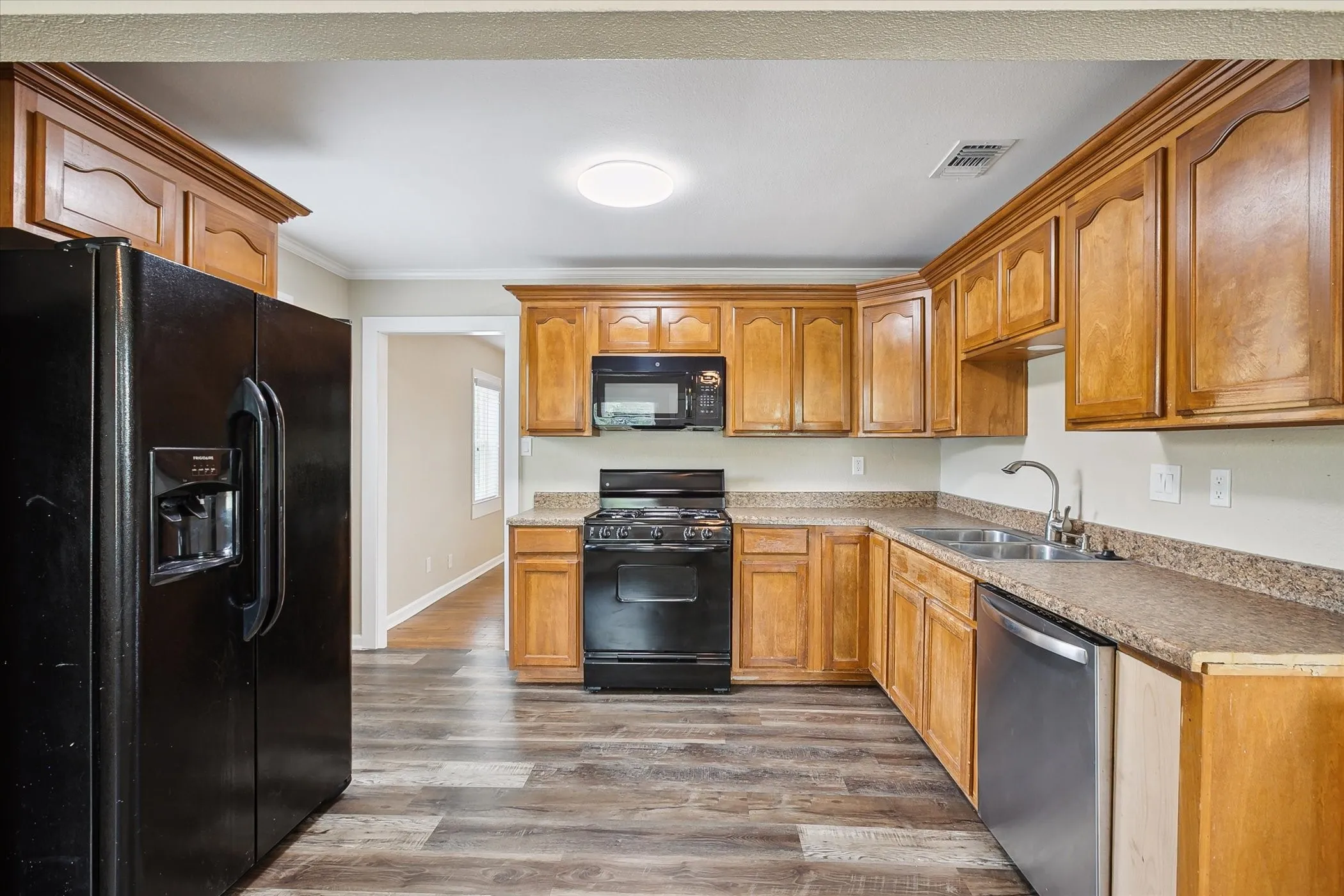 Kitchen featuring laminate flooring, microwave refrigerator and dishwasher