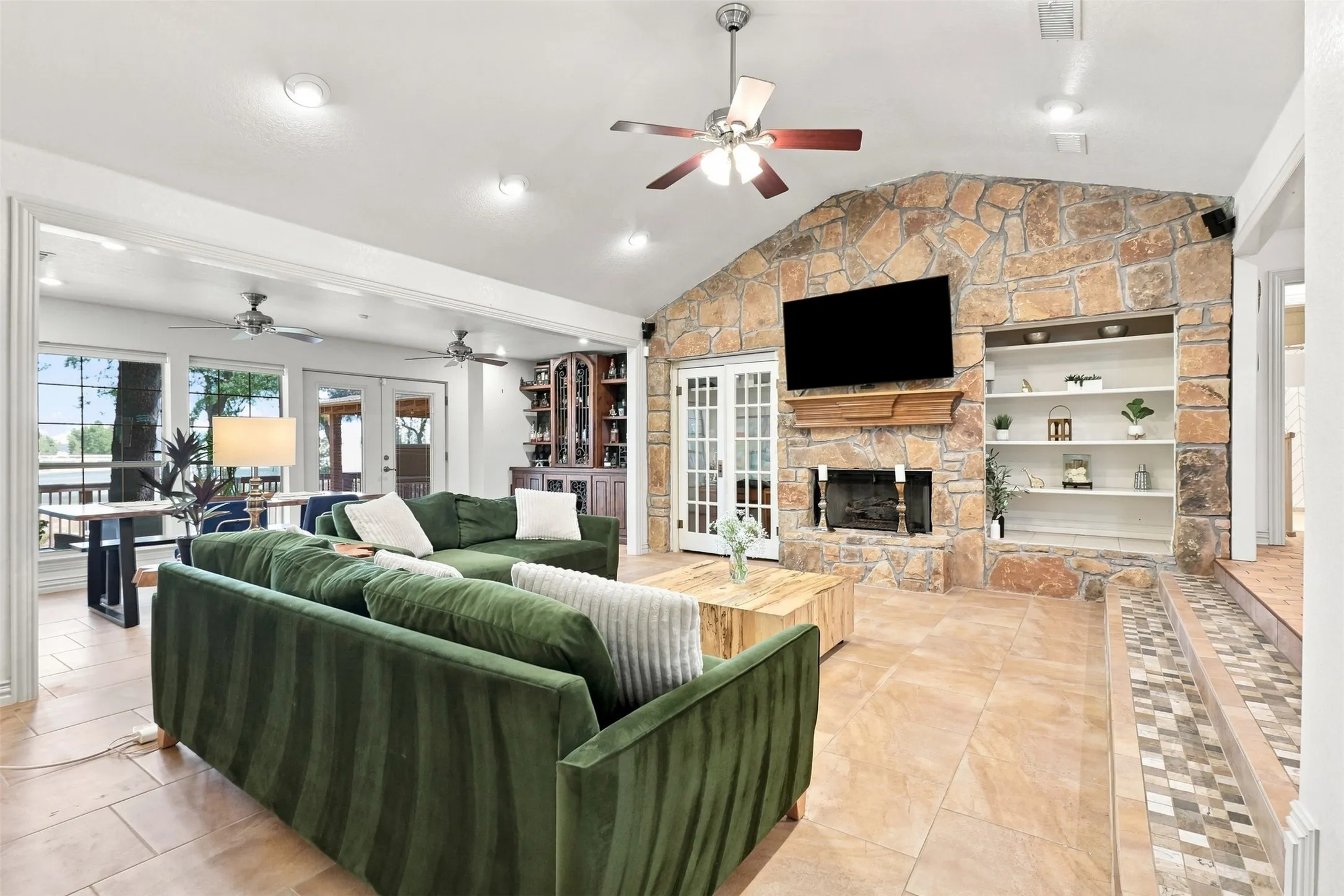 Stone accent wall with built-in shelving, fireplace, and wood mantel