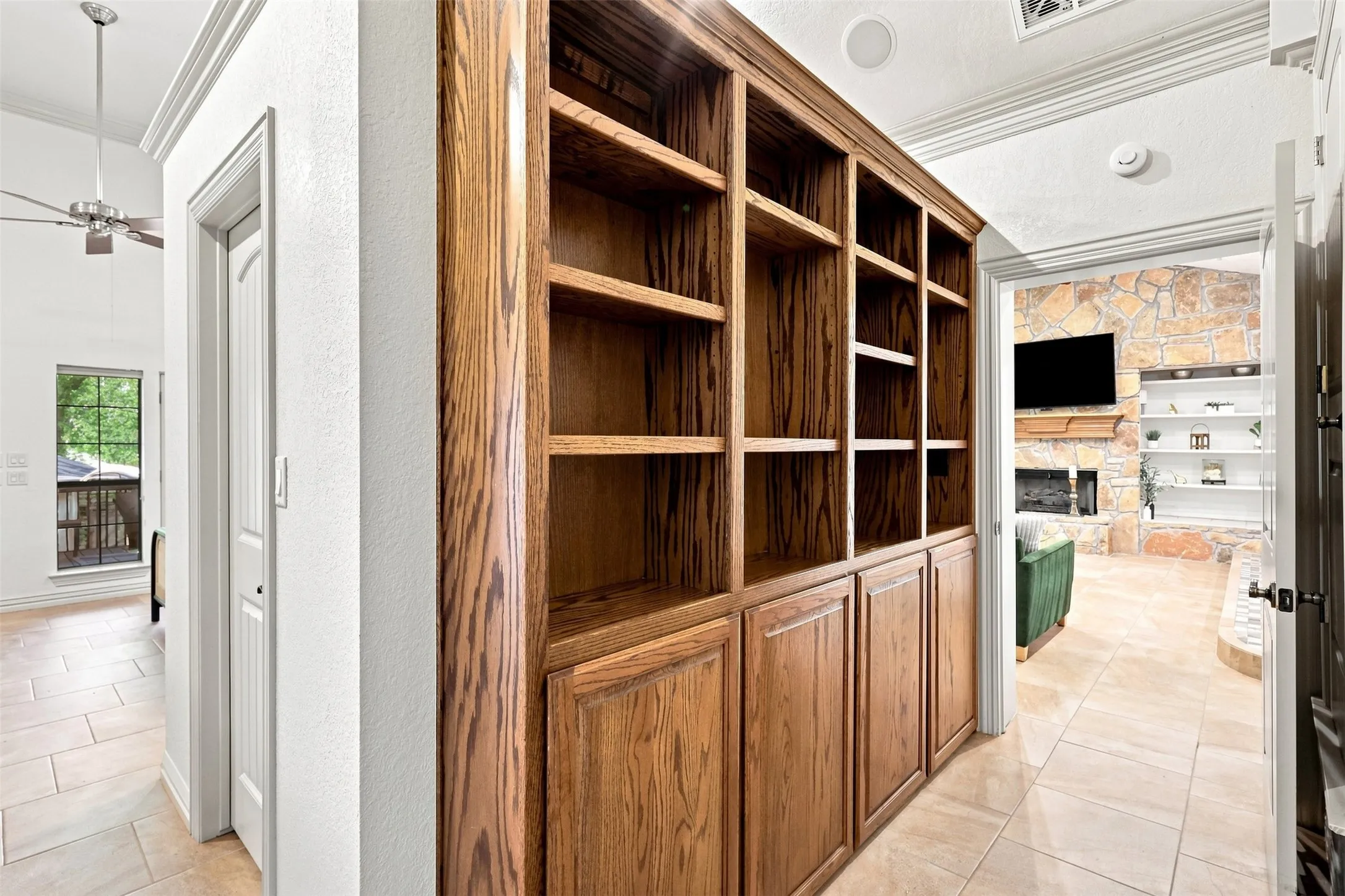 Built-in wood-finish cabinetry with open shelving and closed storage