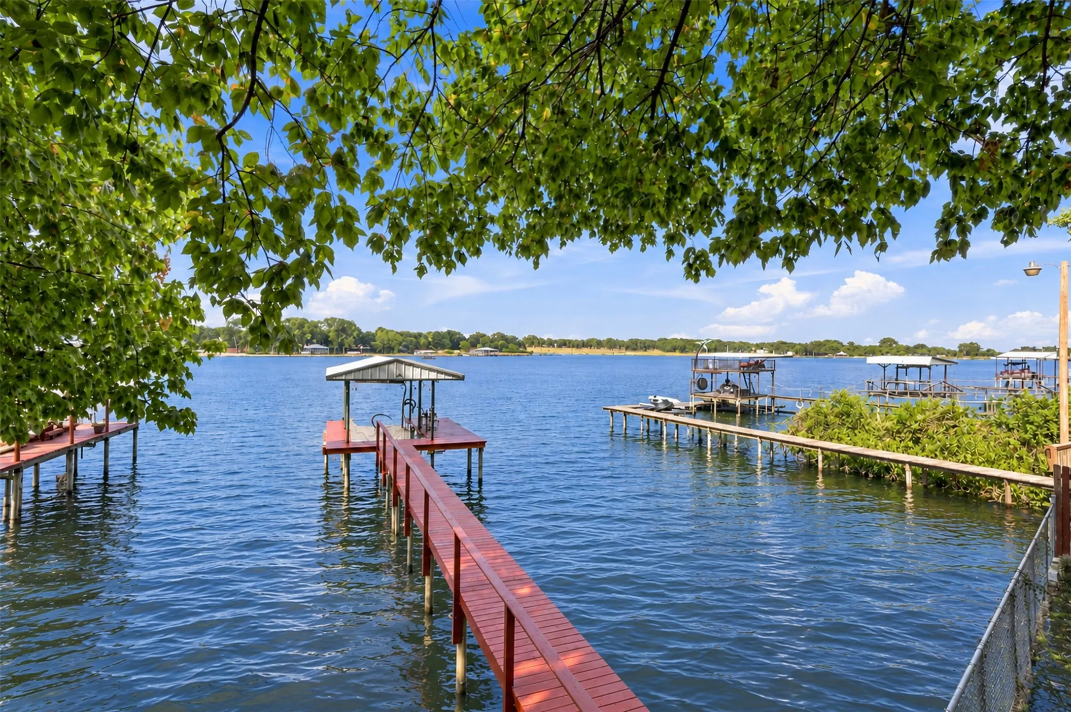 Expansive water frontage featuring multiple docks, a covered boat slip, and direct water access