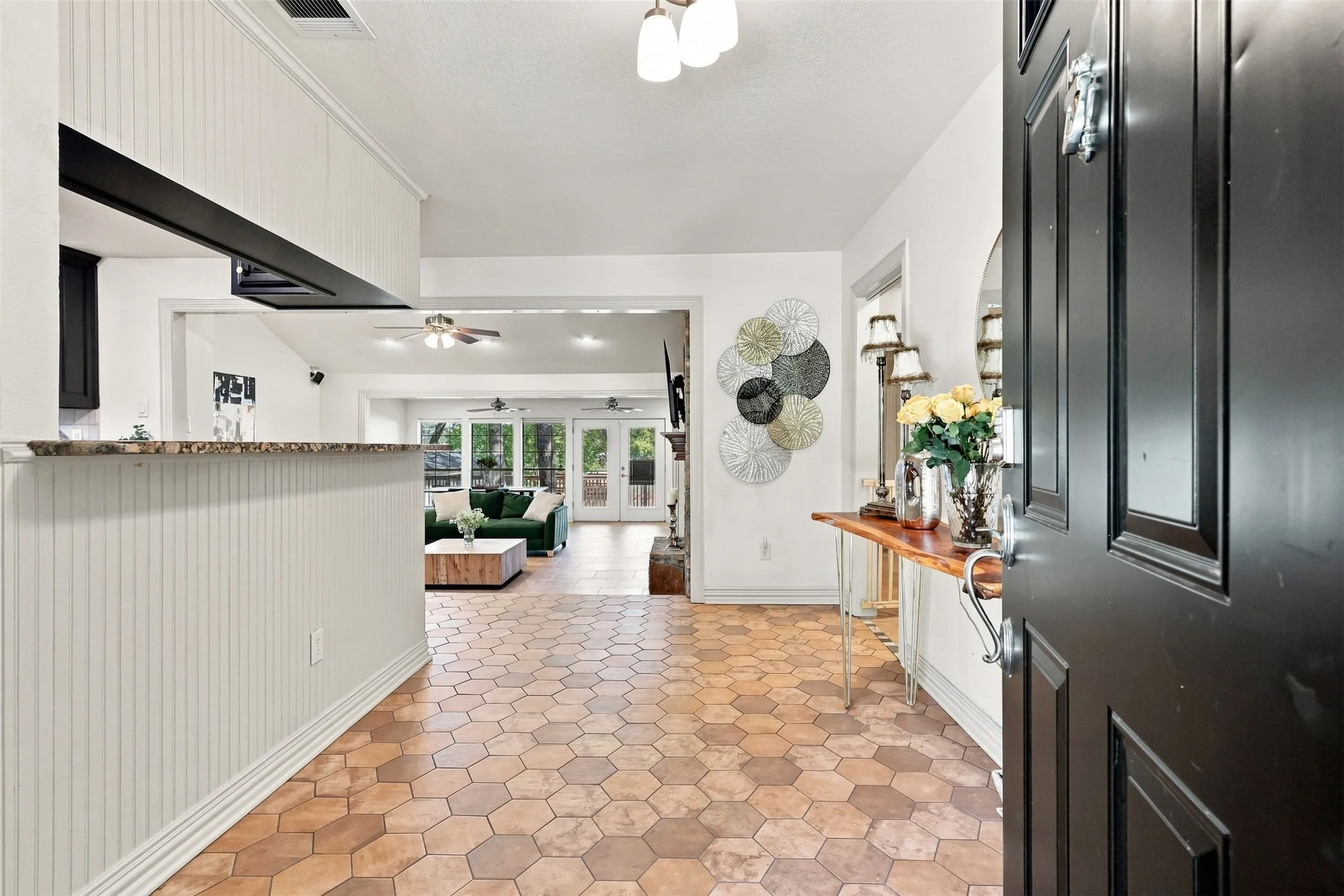 Hexagonal tile flooring, beadboard paneling, granite-finish countertop, recessed lighting, and ceiling fans