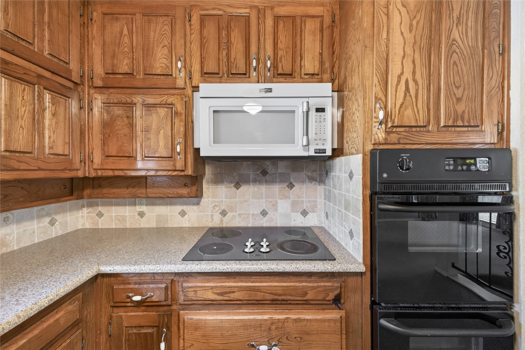 Original kitchen with extensive wood cabinetry and built-in appliances.