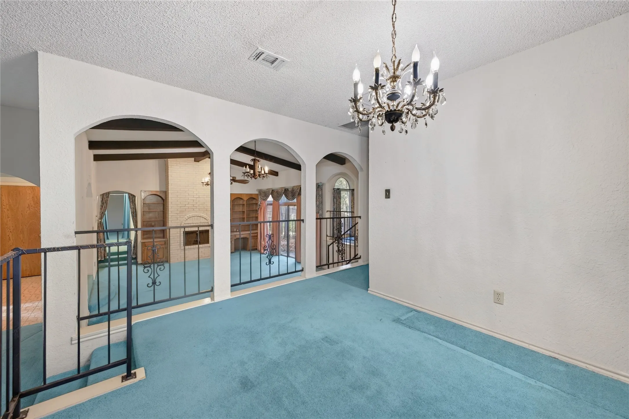 Dining room with arched openings connecting the surrounding living spaces.