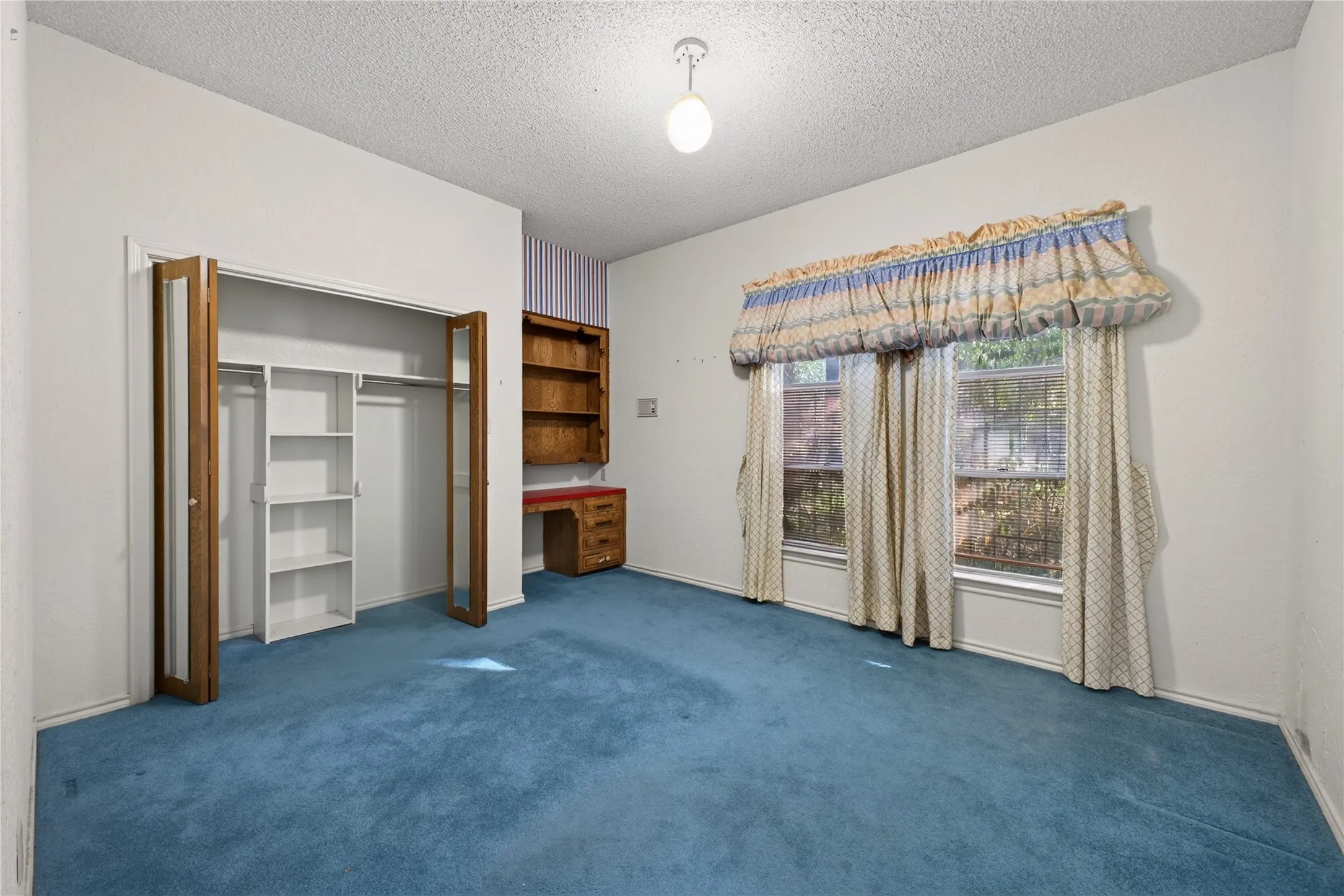 Bedroom with built-in desk and shelving.