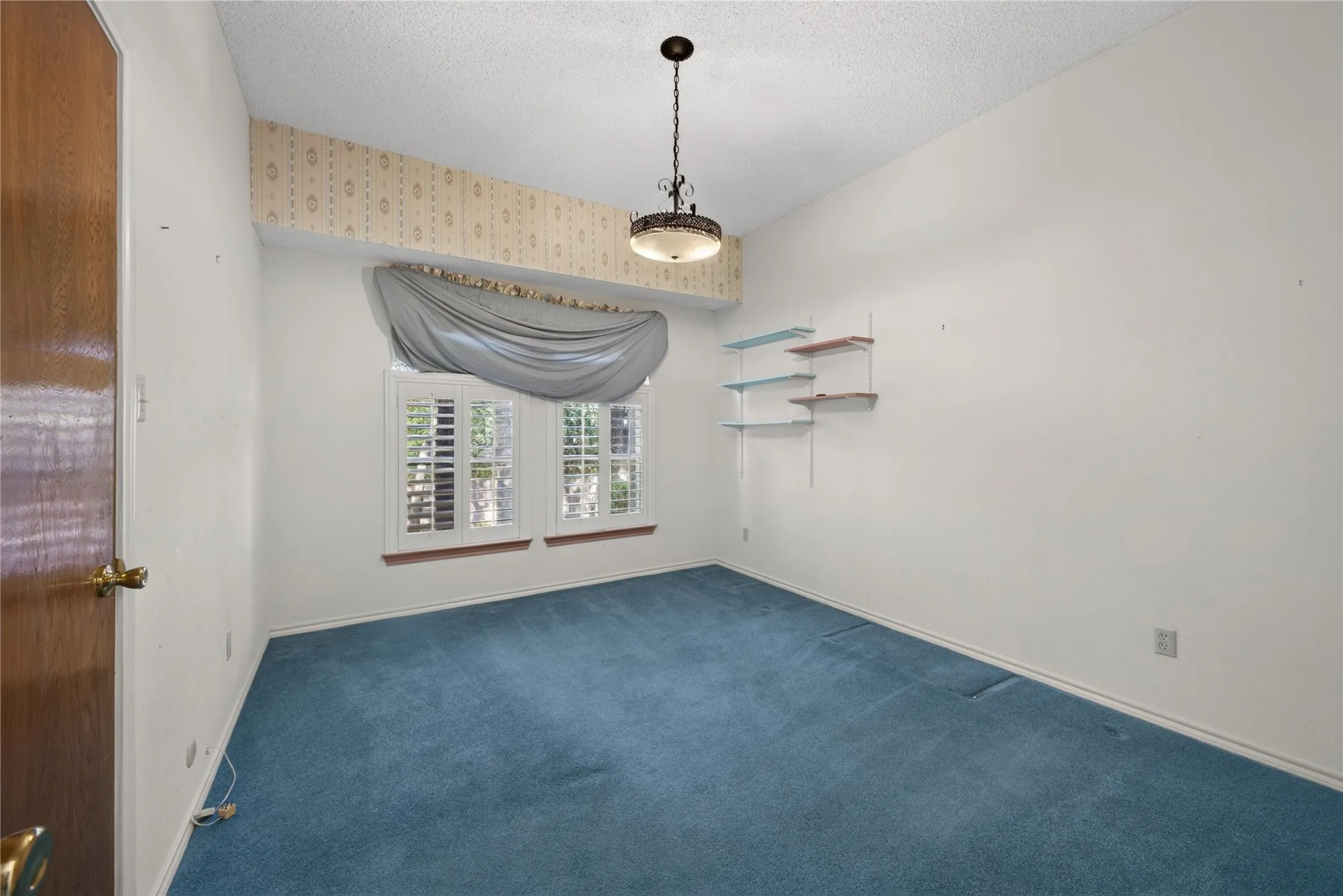 Bedroom with vaulted ceiling and abundant natural light.