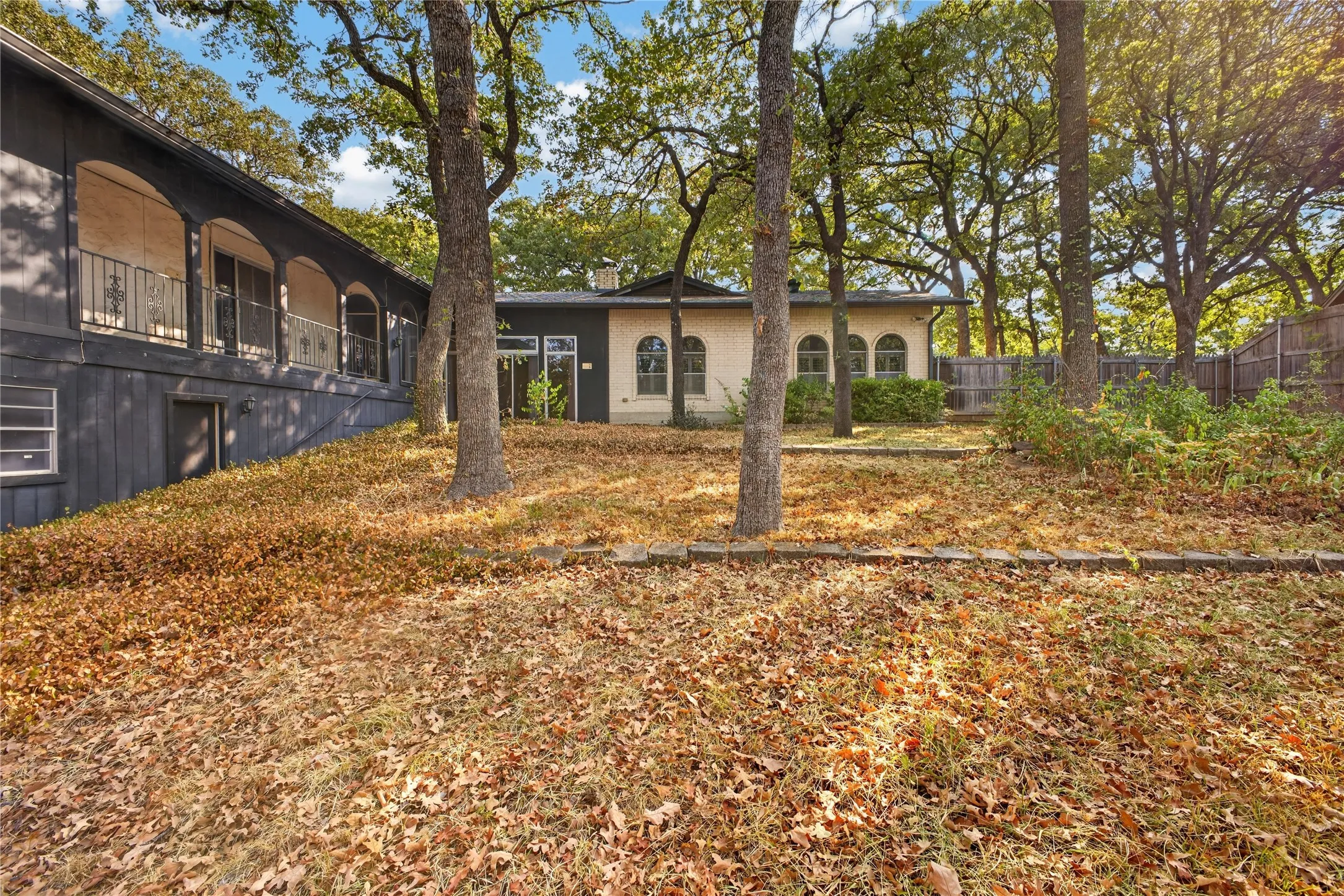Rear exterior showing the home’s distinctive arches and covered primary balcony.