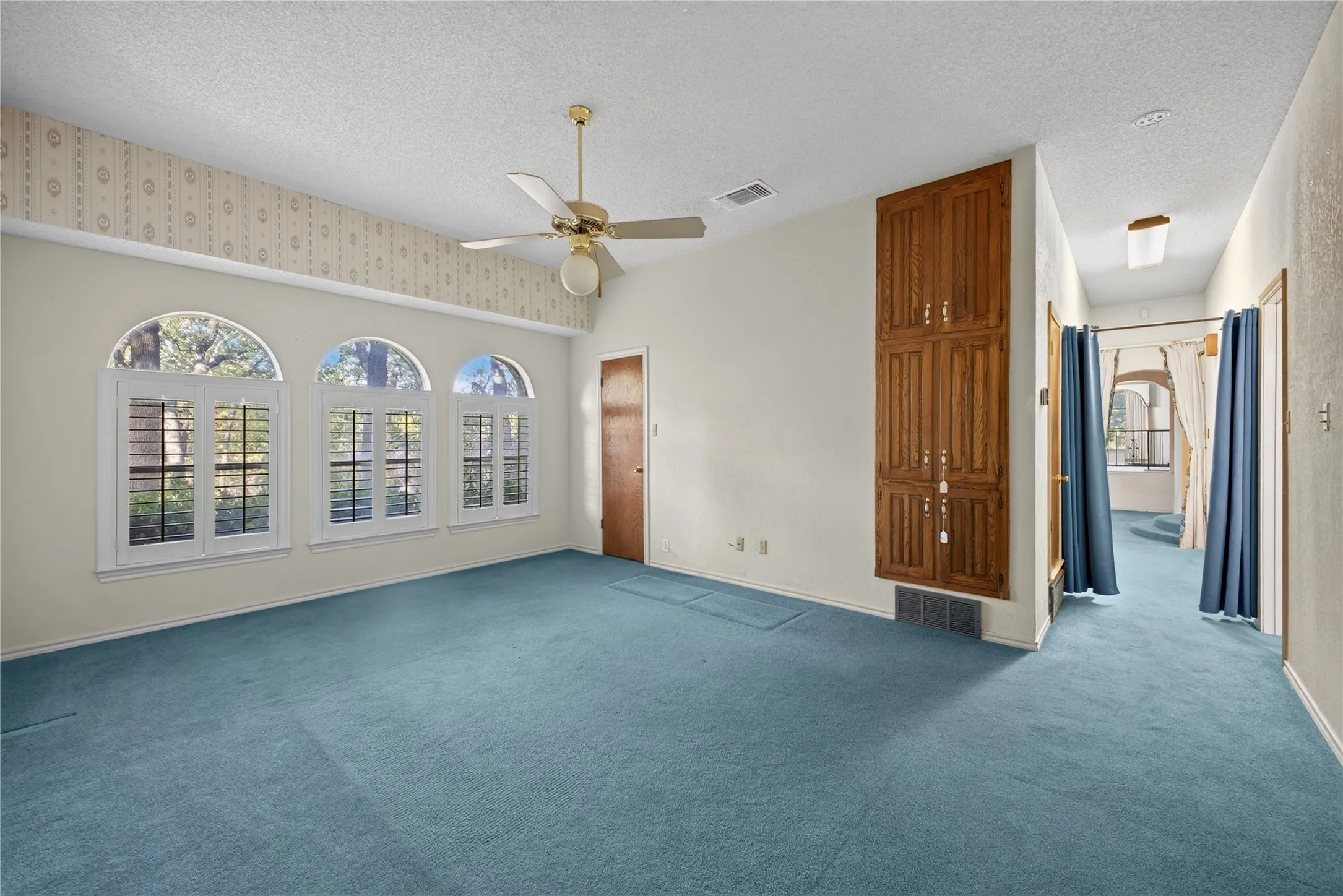 Flexible living space with vaulted ceiling and arched windows.