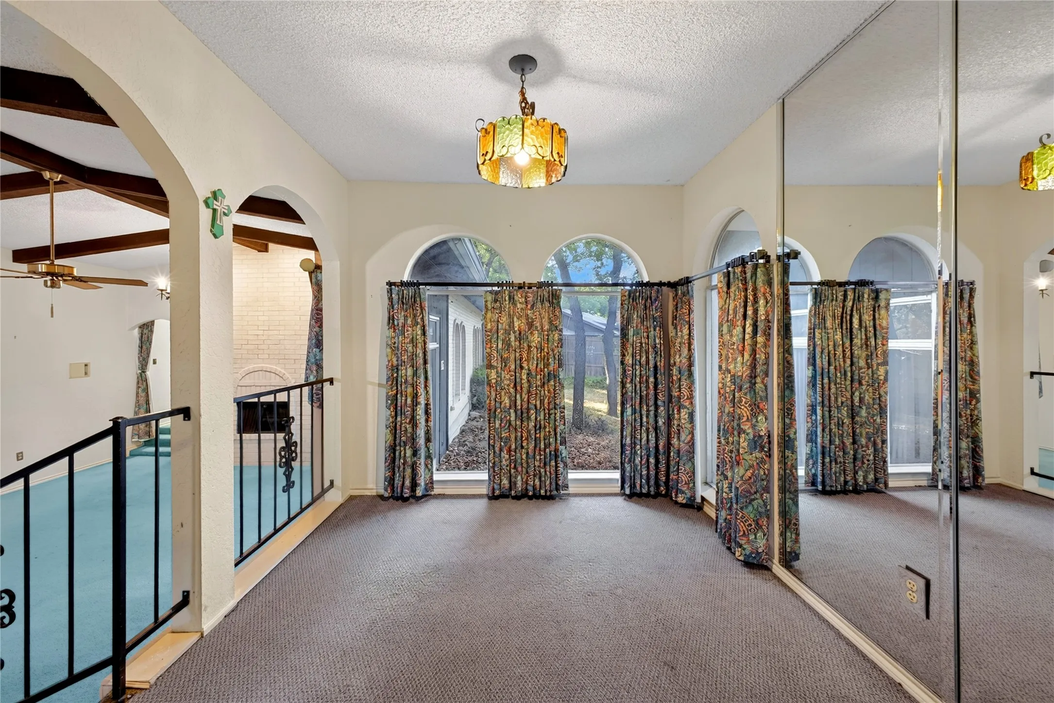 Breakfast area with distinctive arched windows and wrought-iron railing.