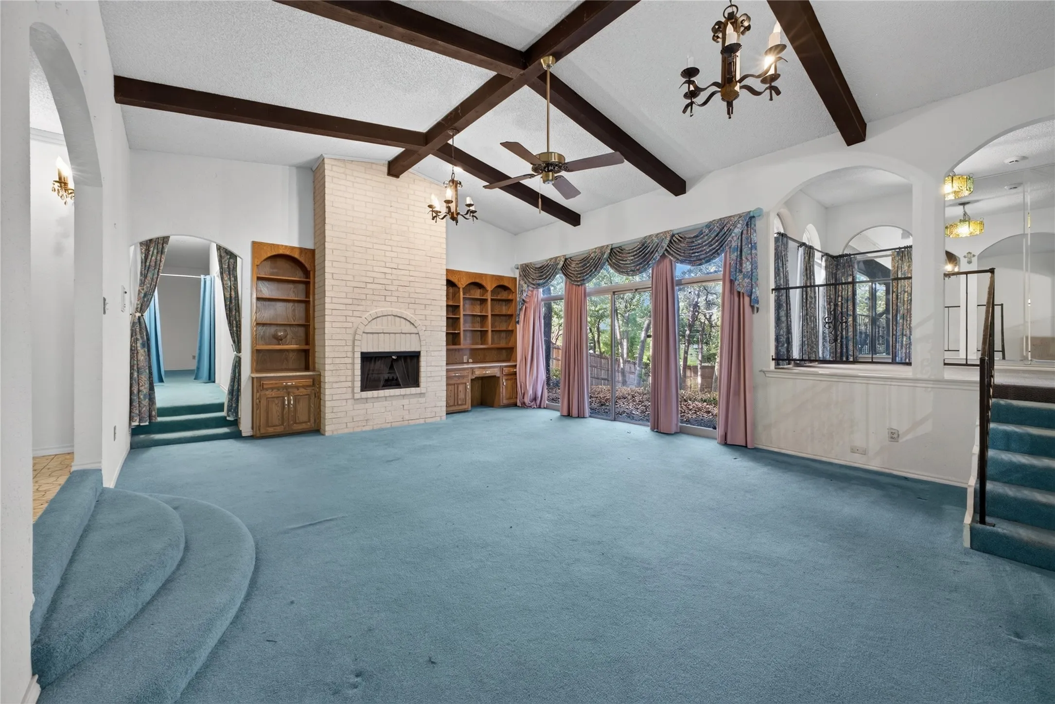 Sunken family room framed by arches and wrought-iron railings.