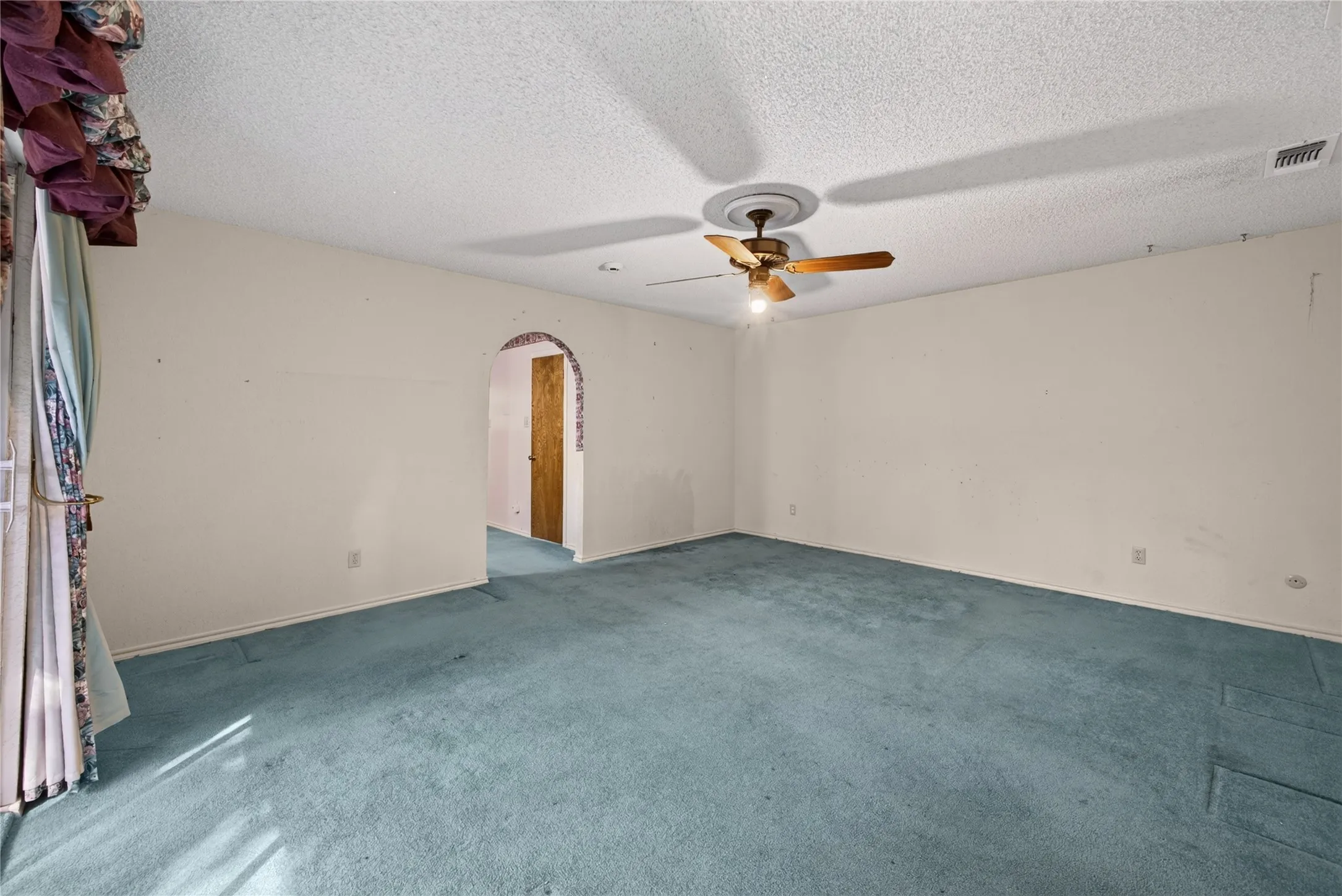Spacious primary bedroom with access to the covered balcony.