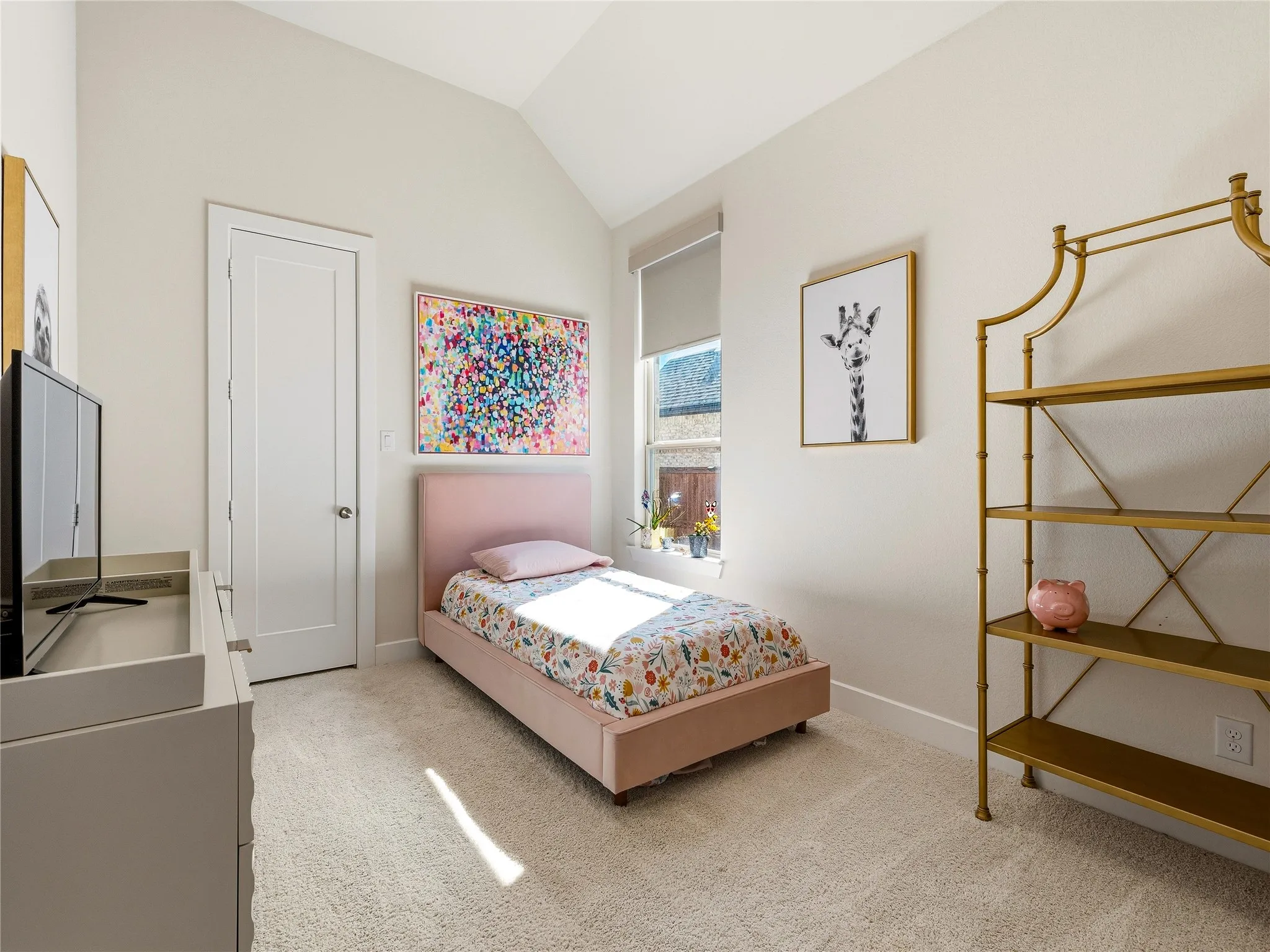 Vaulted ceiling, neutral wall paint, carpeted flooring, window with roller shade, interior door with paneling