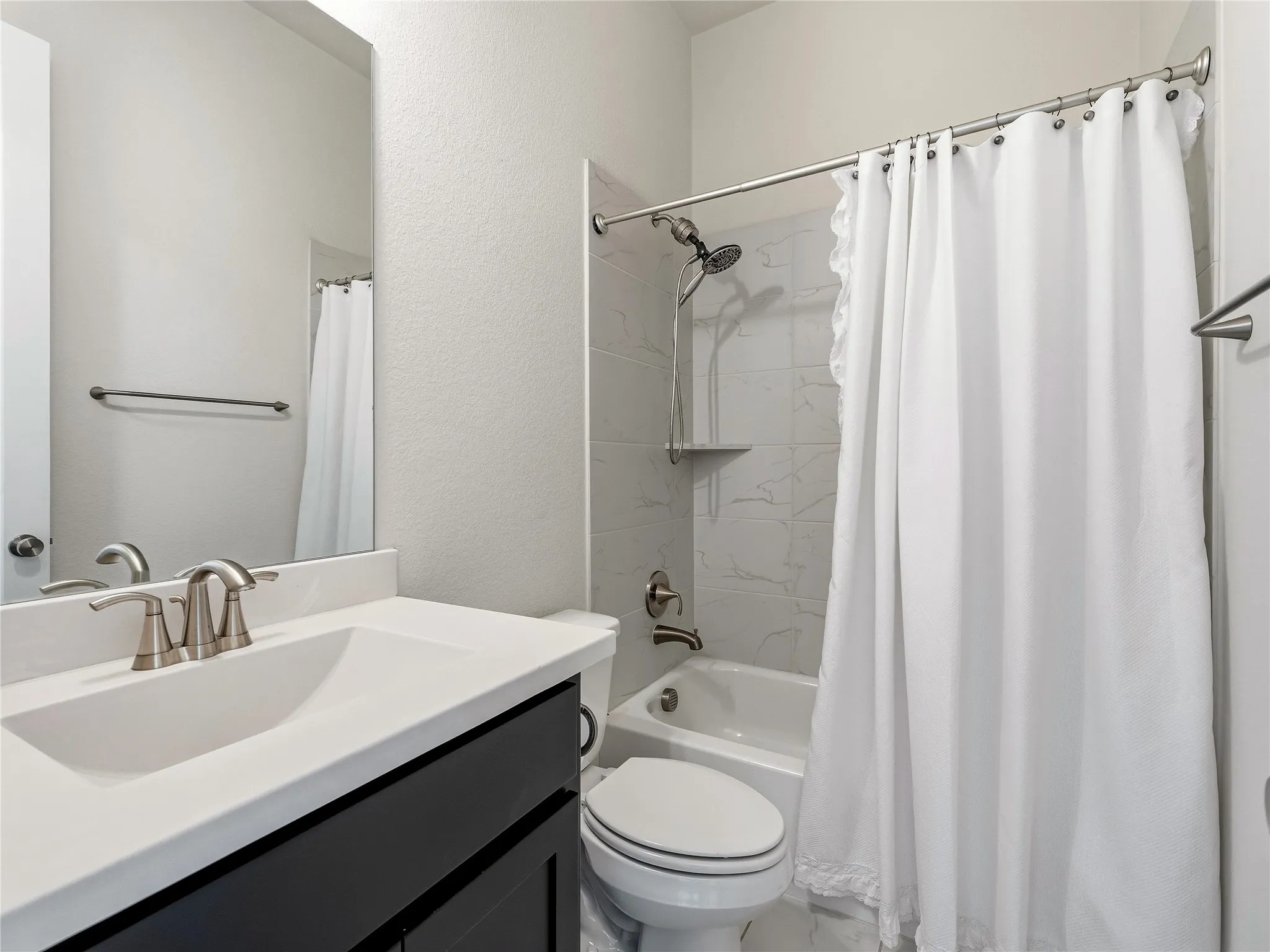 Bathroom with a vanity featuring a single basin sink, brushed nickel faucet, and dark wood-finish cabinetry