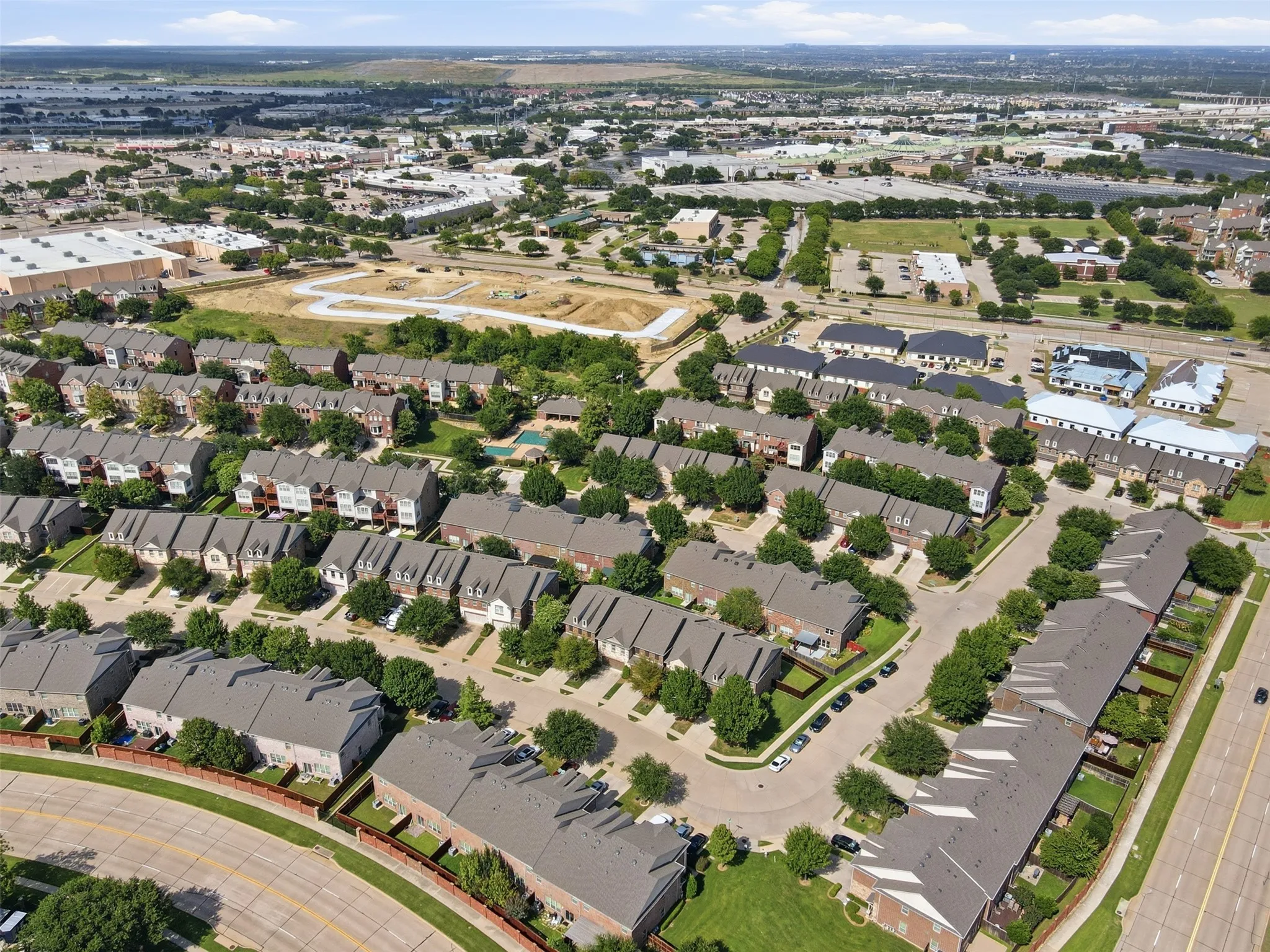Aerial perspective of a developed residential community with townhomes and detached properties