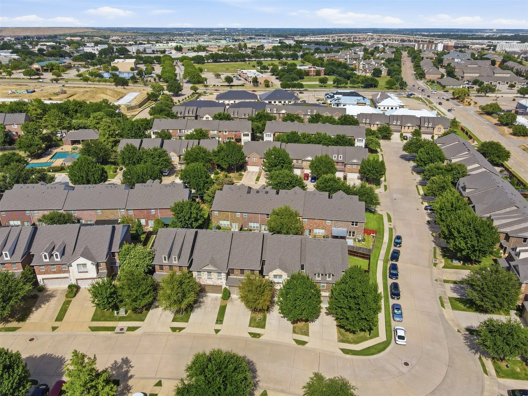 Residential neighborhood with mature trees, paved streets, and a mix of attached and detached homes