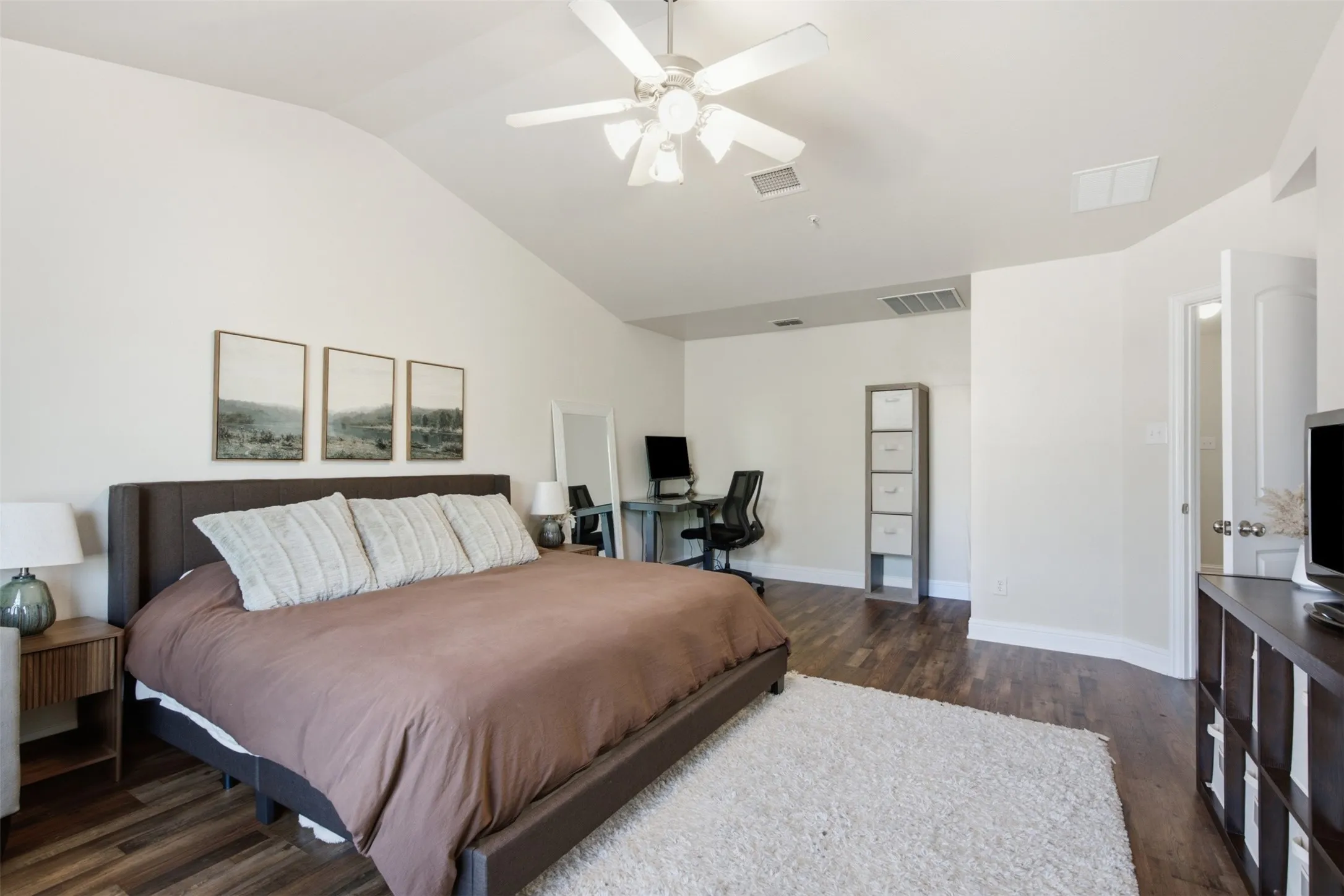 Vaulted ceilings, wood-finish flooring, ceiling fan, and white walls