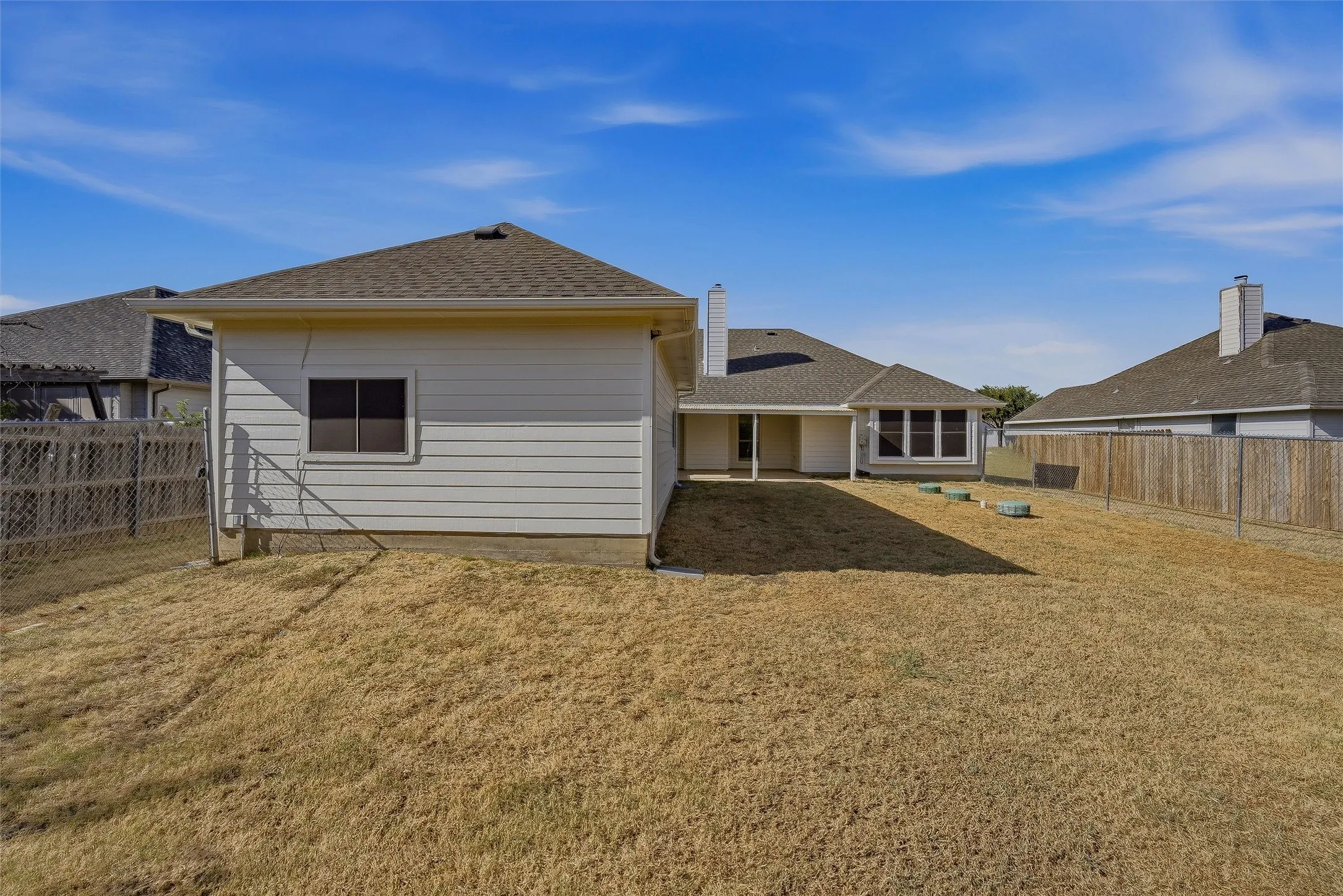 Expansive yard space with a wood privacy fence and chain link fencing