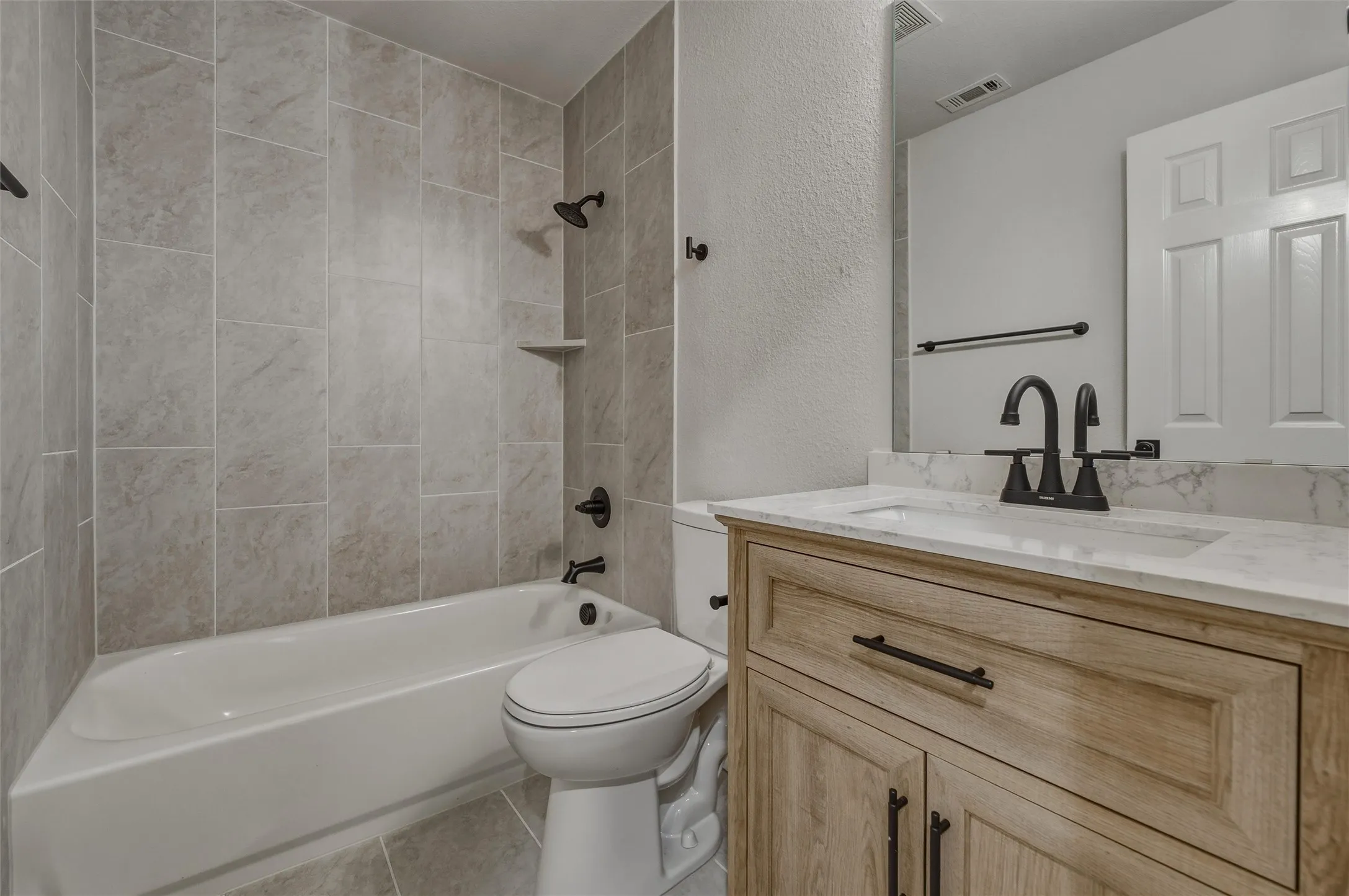 Full bathroom featuring a single vanity with wood-finish cabinetry, a white countertop, and a vessel sink