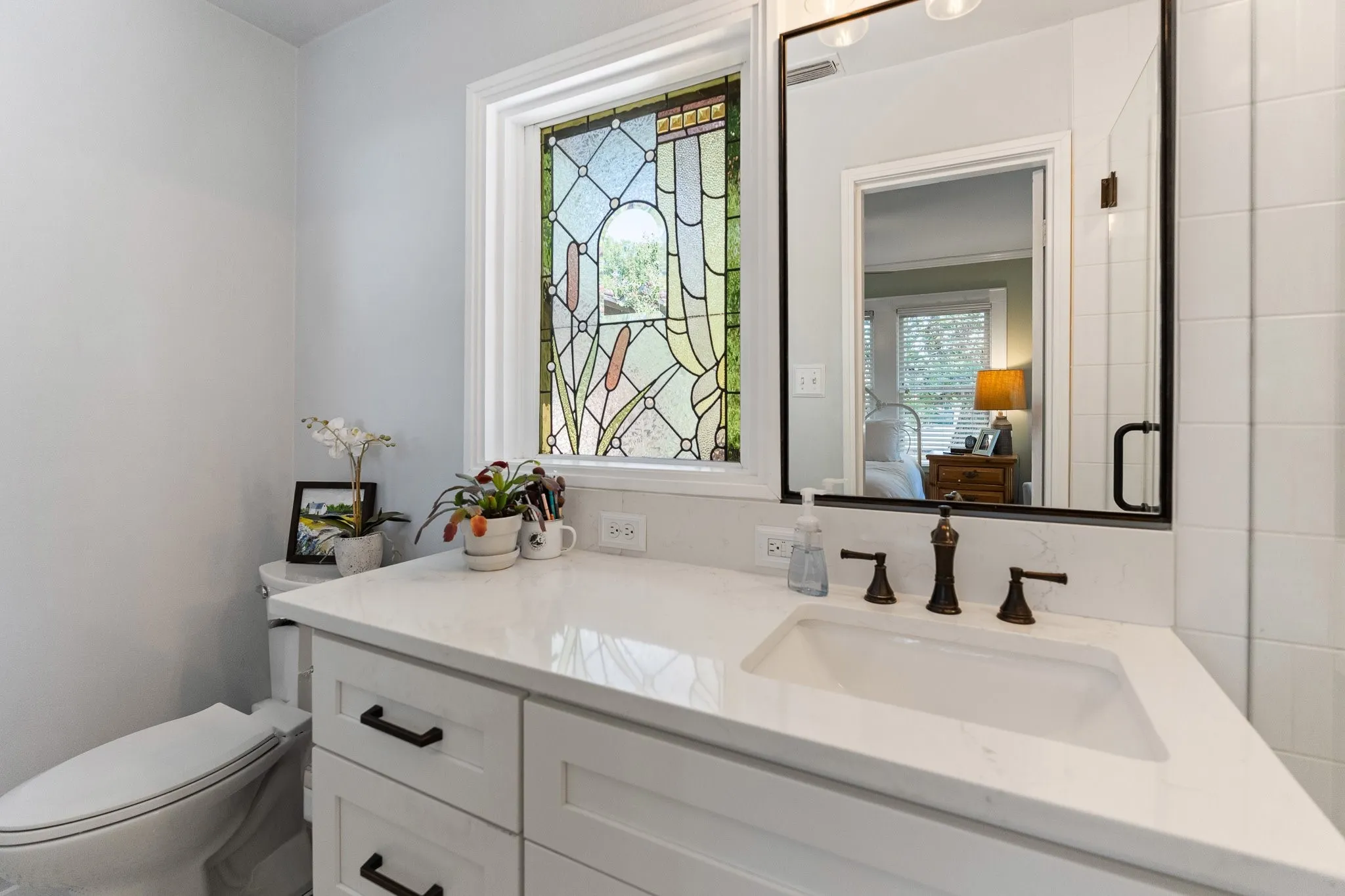 Primary bathroom was totally redone with quartz and a walk in shower with frameless glass doors and a beautiful stained glass window!
