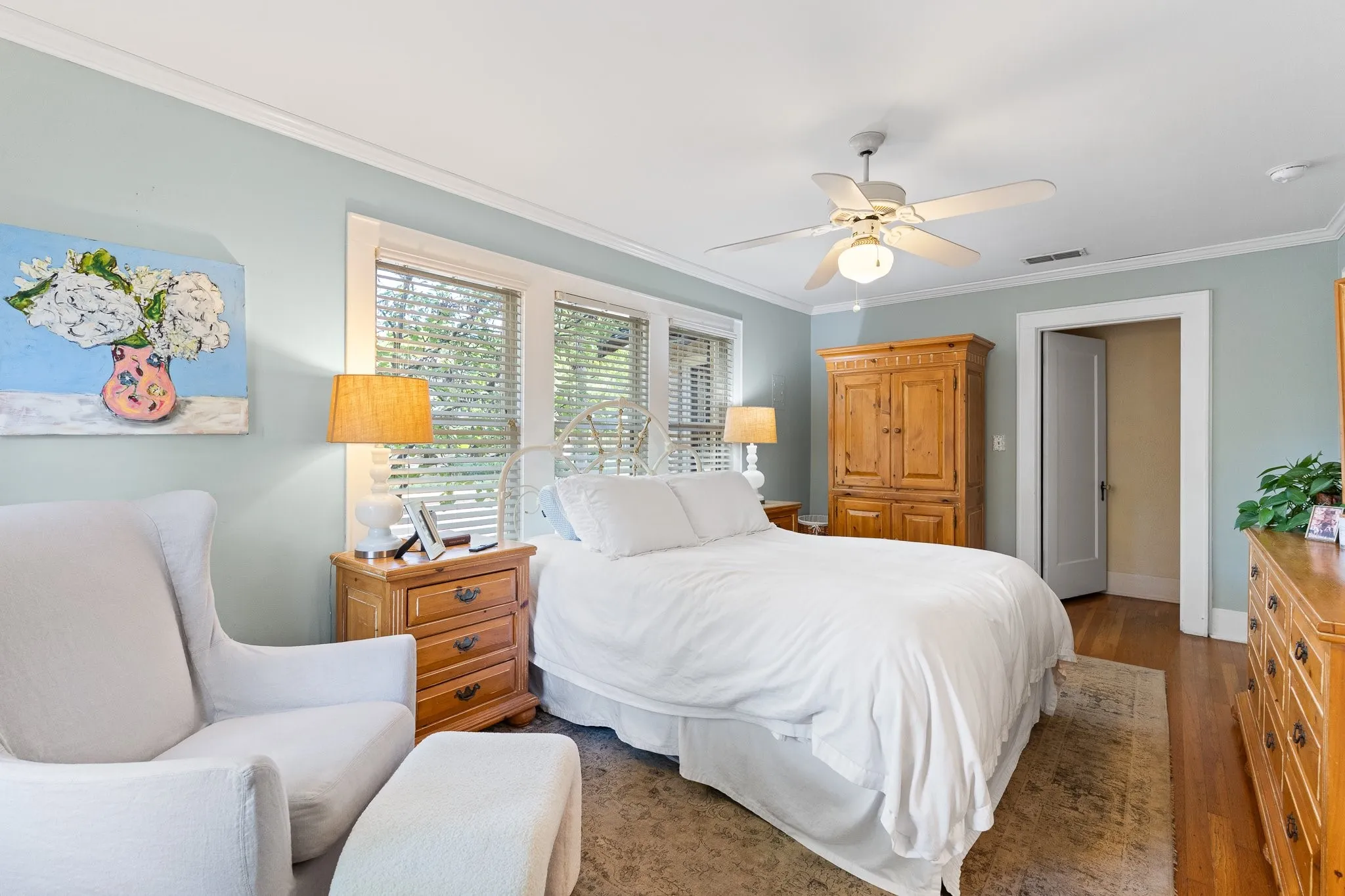 Another view of the primary bedroom. Read hardwood floors. Great window moldings.