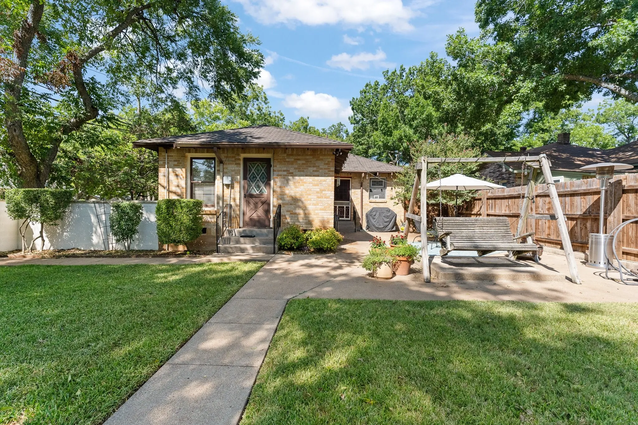 This is a shot of the back of the house. The brown door on the left goes into the primary bedroom. The door on the right, by the grill goes into the kitchen.