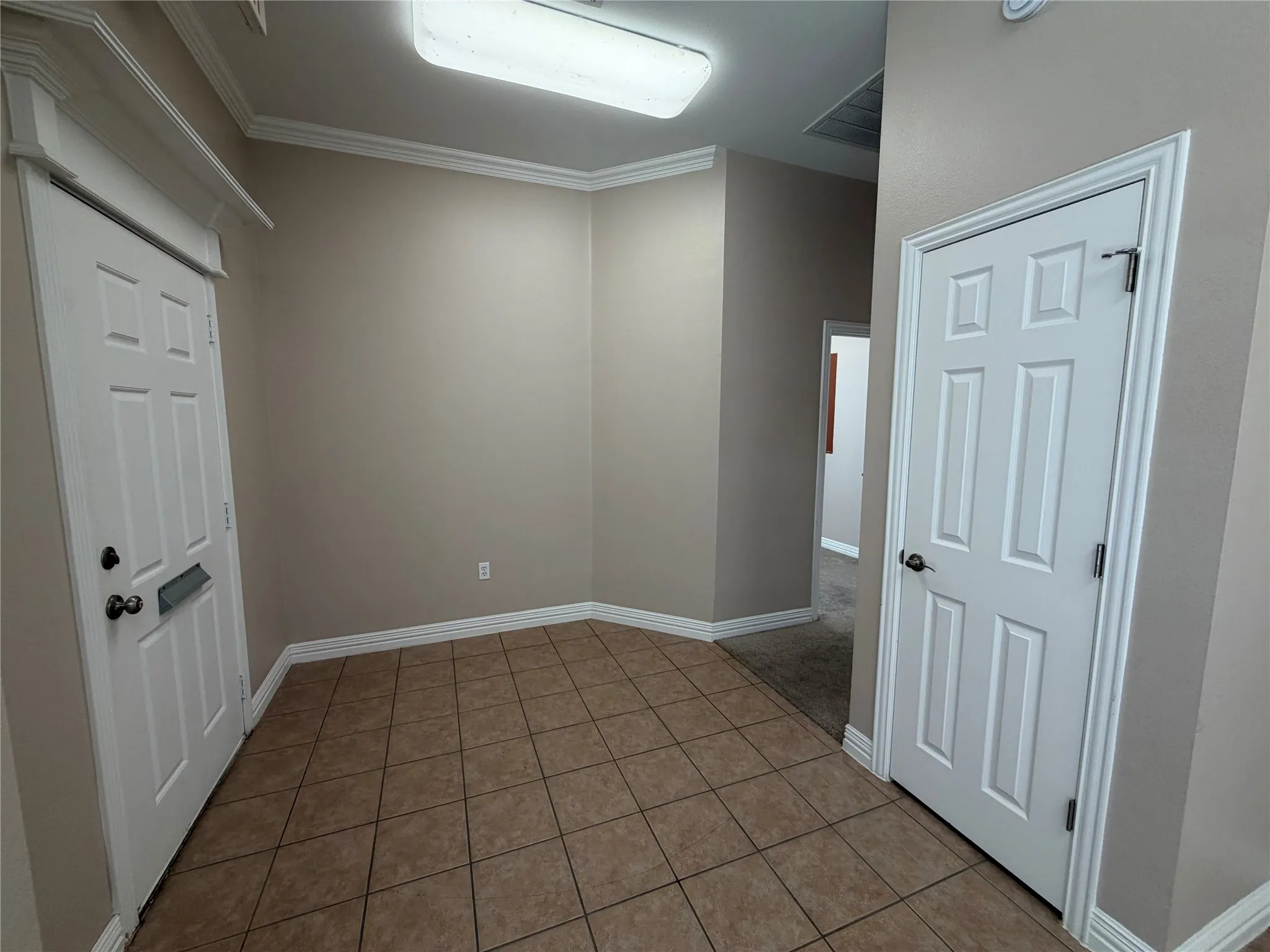 Tiled entrance with closet and hall leading to conference room and offices.
