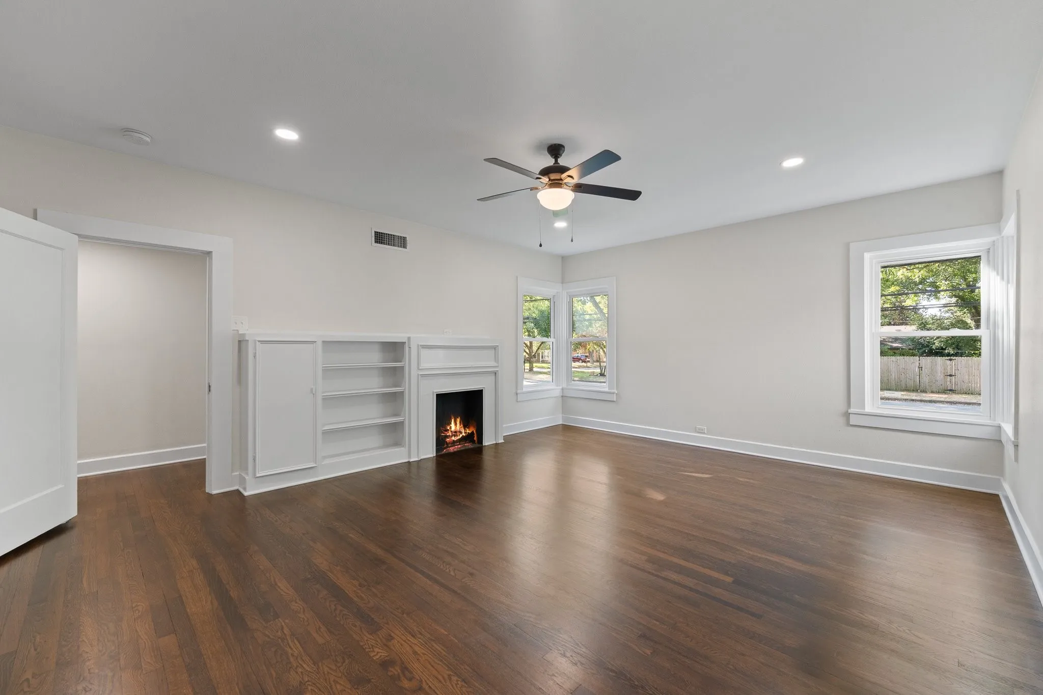 This primary bedroom downstairs has built ins, recessed lighting, a ceiling fan and a non-working fireplace, but it's an electric fireplace so you could buy some electric logs and put them in! There's already a plug there~